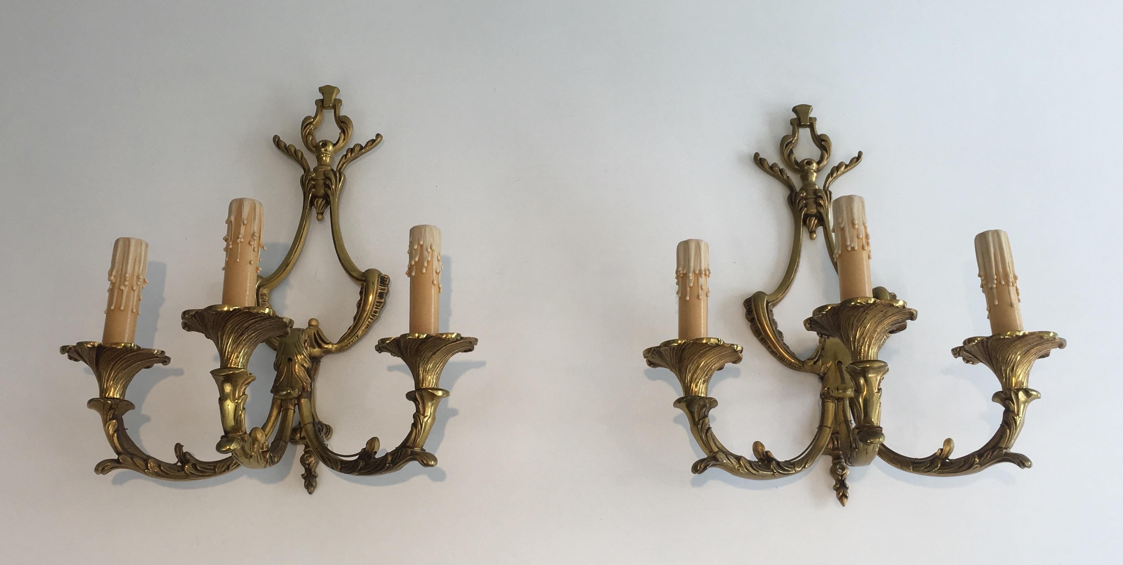 This pair of Louis XV style wall sconces is made of bronze sconces. These wall lights have 3-light. They were made in France, circa 1960.