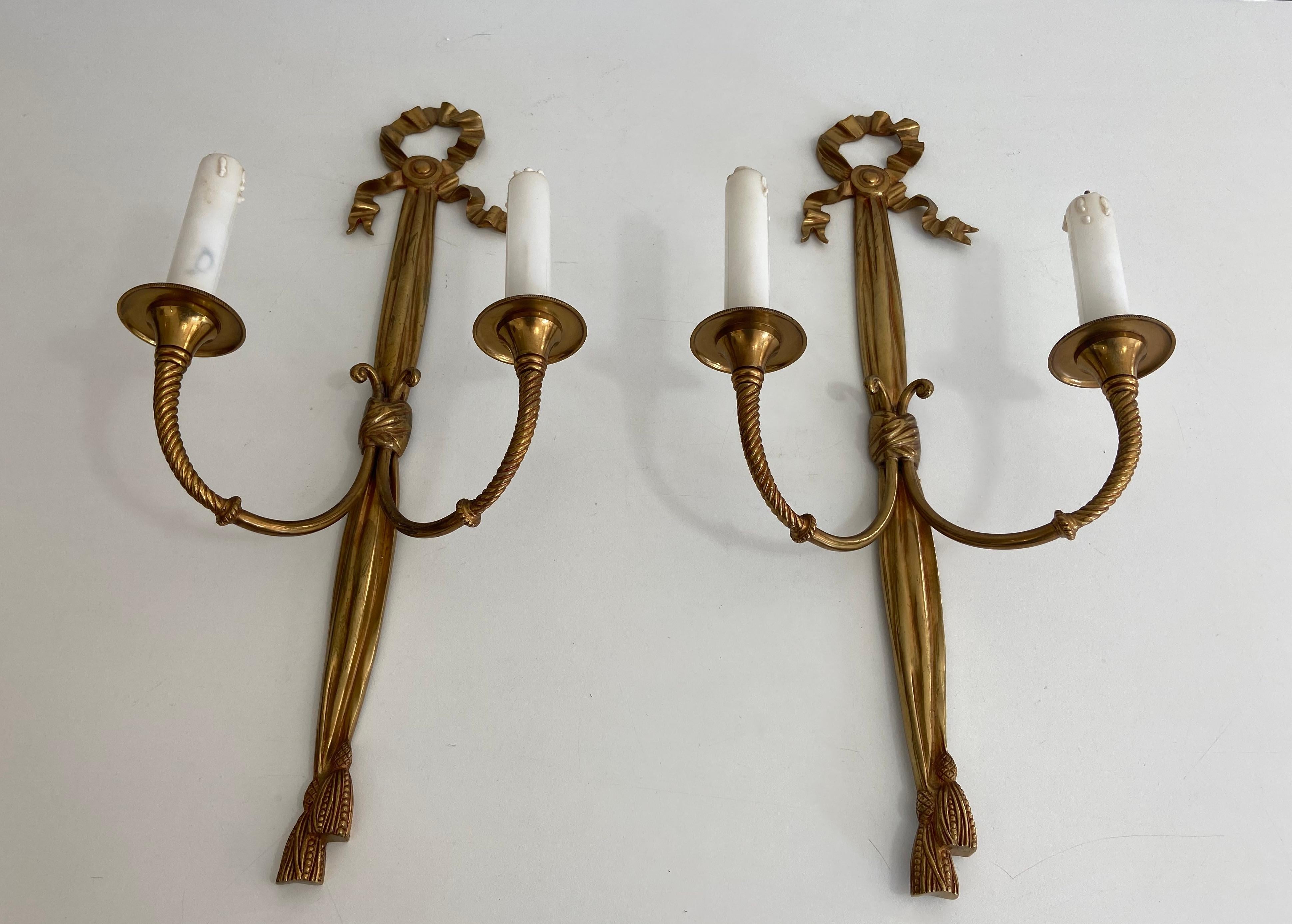 This pair of louis the 16th style wall lights is made of bronze with noddles and ribbons. This is a French work. Circa 1940.
 