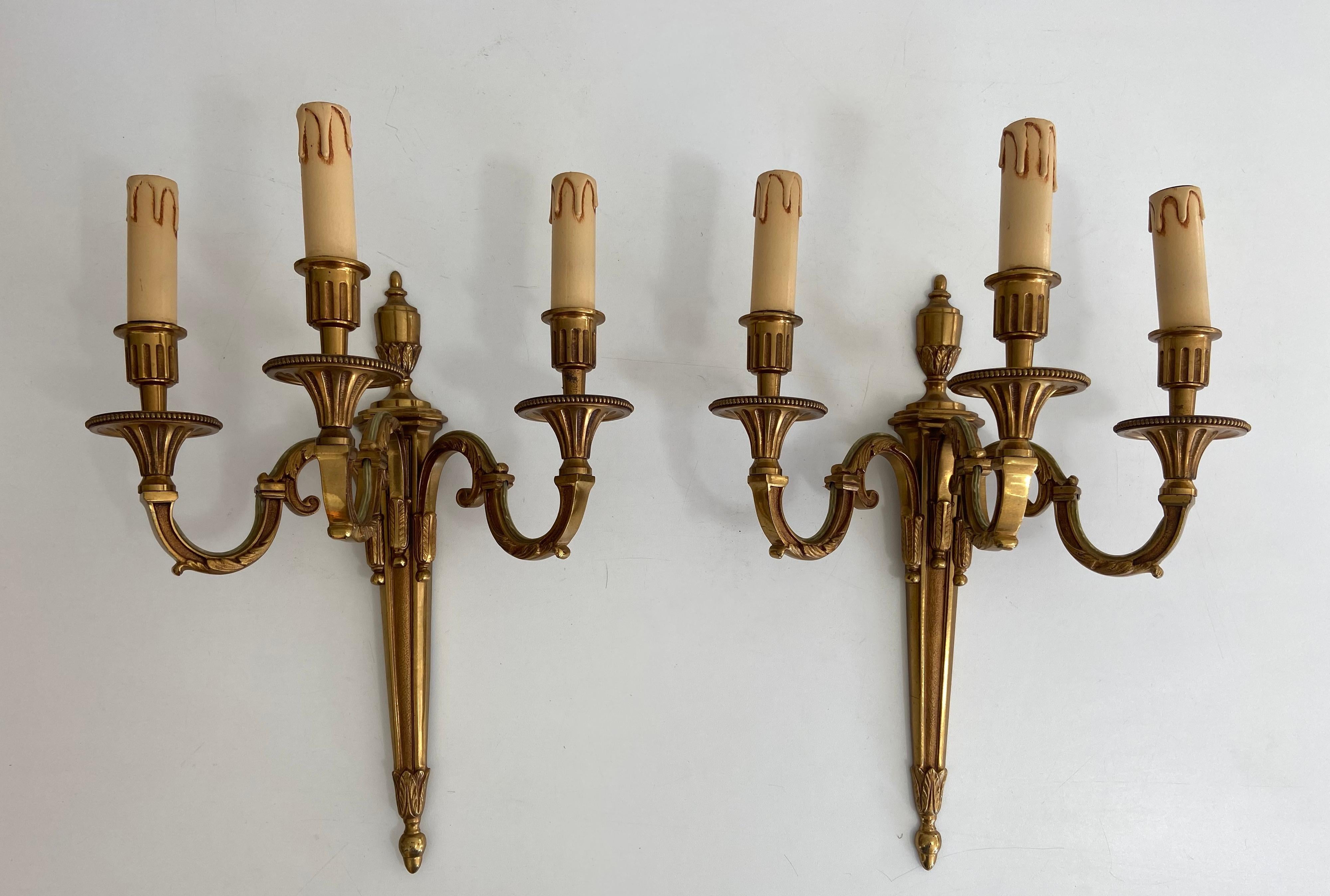 This pair of Louis the 16th style 3 arms wall lights are made of bronze. This is a French work by Maison Lucien Gau. Circa 1950.