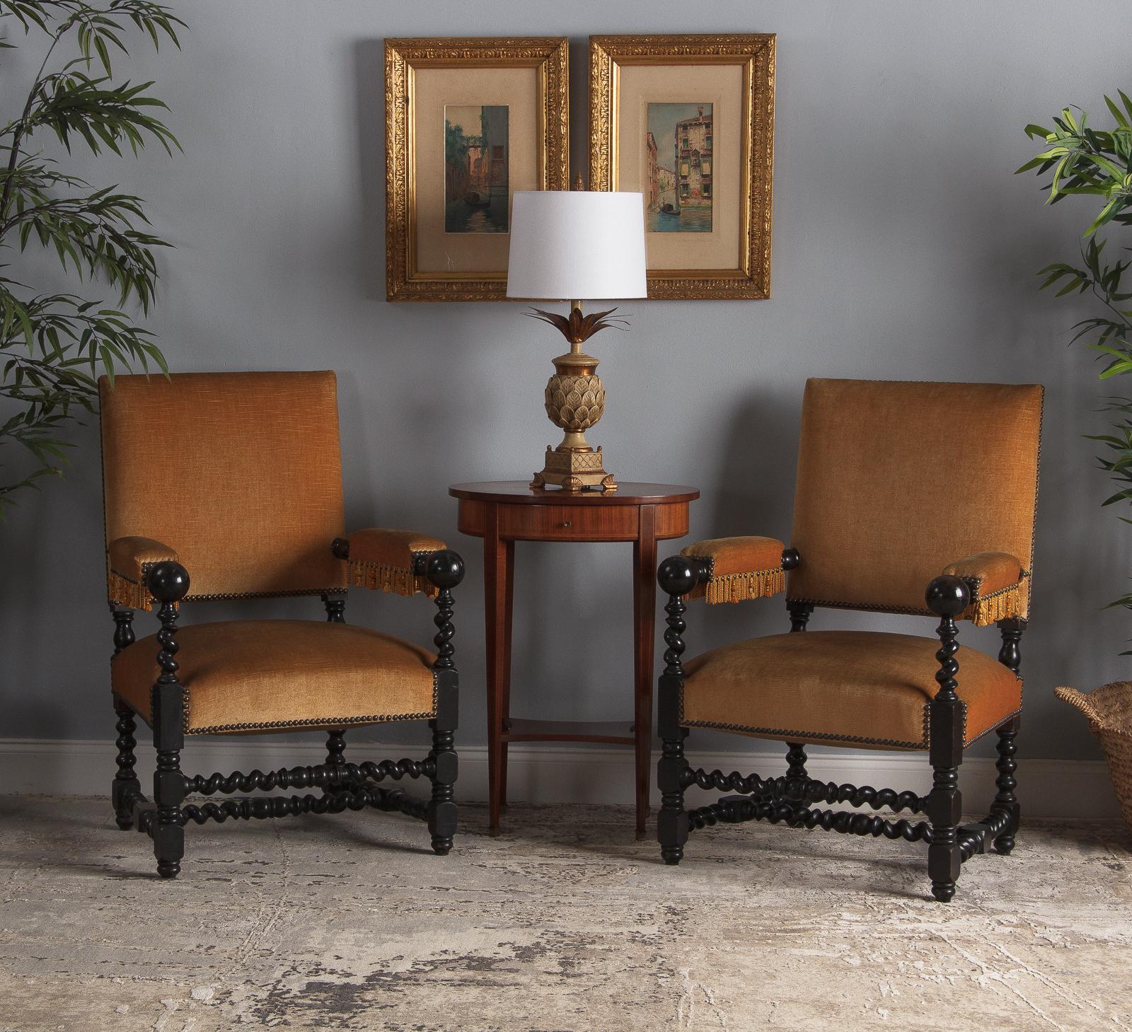 Stylish looking pair of Louis XIII style armchairs that date from the Napoleon period, circa 1870s. The ebonized pear wood frame features baluster and spiral legs and stretcher. The armrests terminate with a ball. The upholstery is velvet in gold