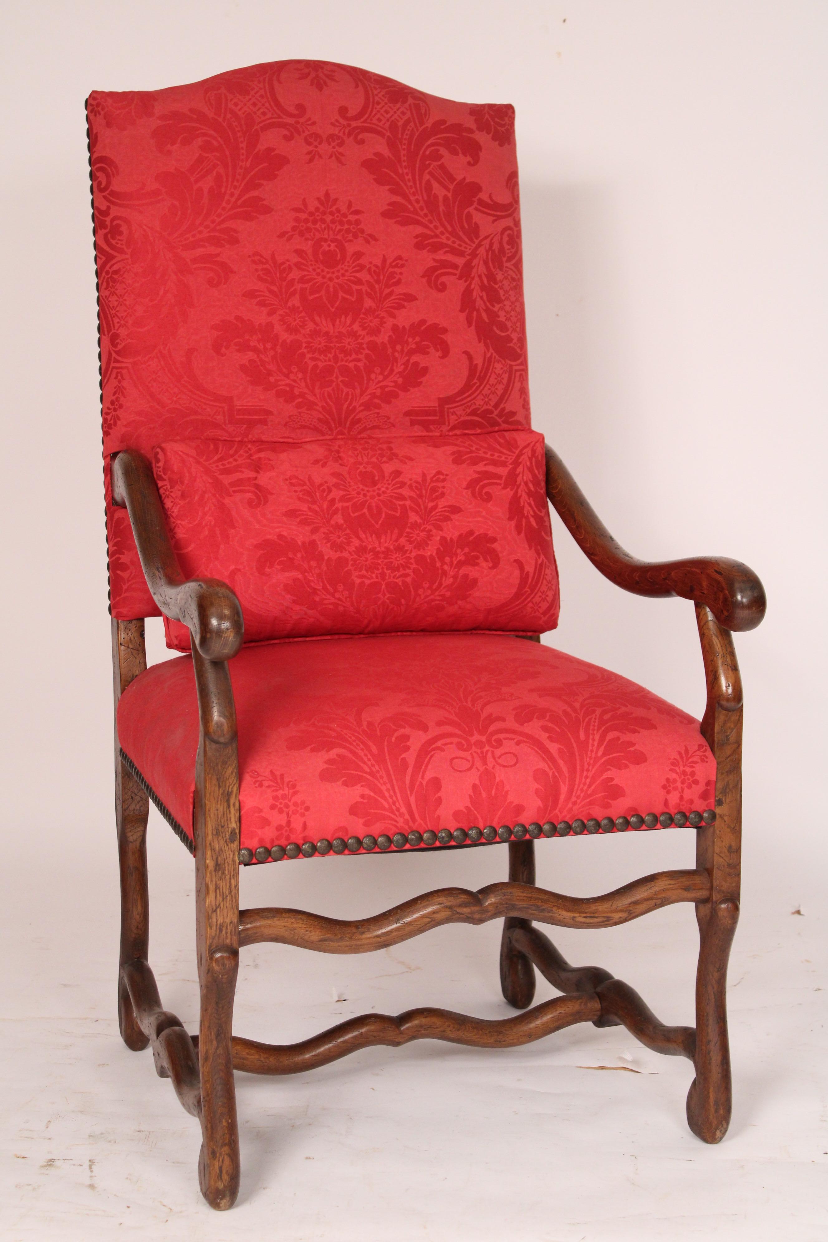 Pair of Louis XIV style oak armchairs, circa 1930's. With cupid's bow crest rail, serpentine shaped arms and os du muton legs. Recently re upholstered in red cotton fabric with brass nail head trim. Mortise, tenon and peg construction. Approximate