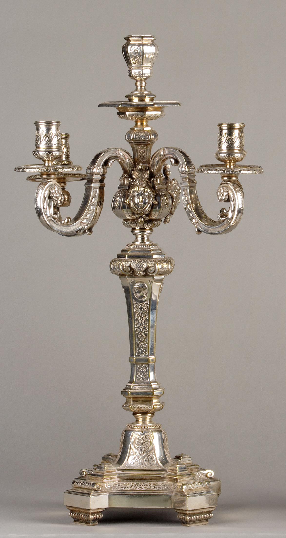 Pareja de candelabros de cinco luces estilo Luis XIV. Bronce cincelado y plateado. Ornamentada con palmetas, medallones y máscaras femeninas. Vástago central con motivos guillochés, que descansa sobre una base octogonal.

Para enlazar: candelero
