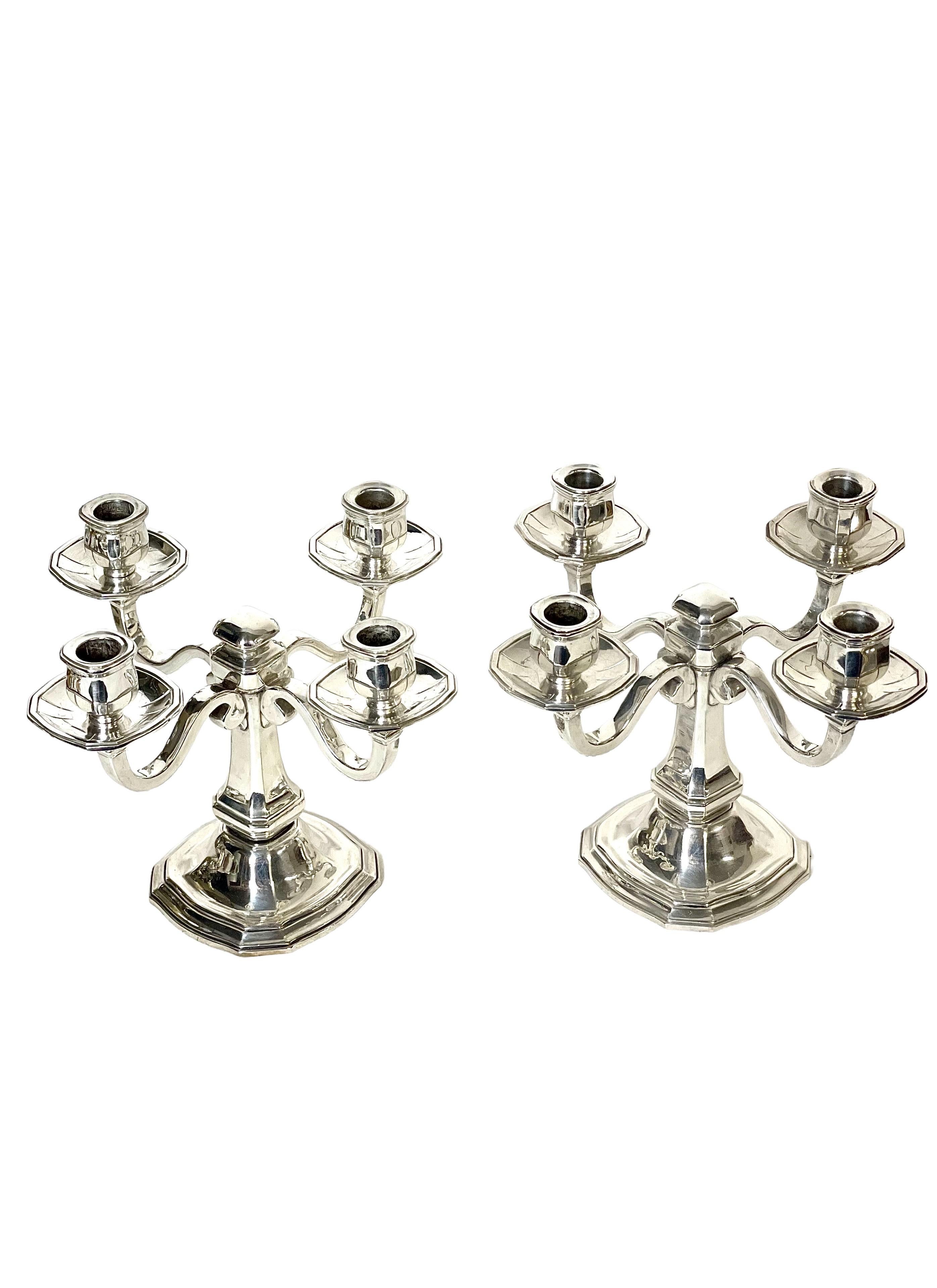 An exceptionally fine and matching pair of Louis XIV style four-light candelabra, in gleaming, silver-plated bronze. These striking candle holders are raised on tiered, octagonal bases, their square-sided central pillars rising to meet the four