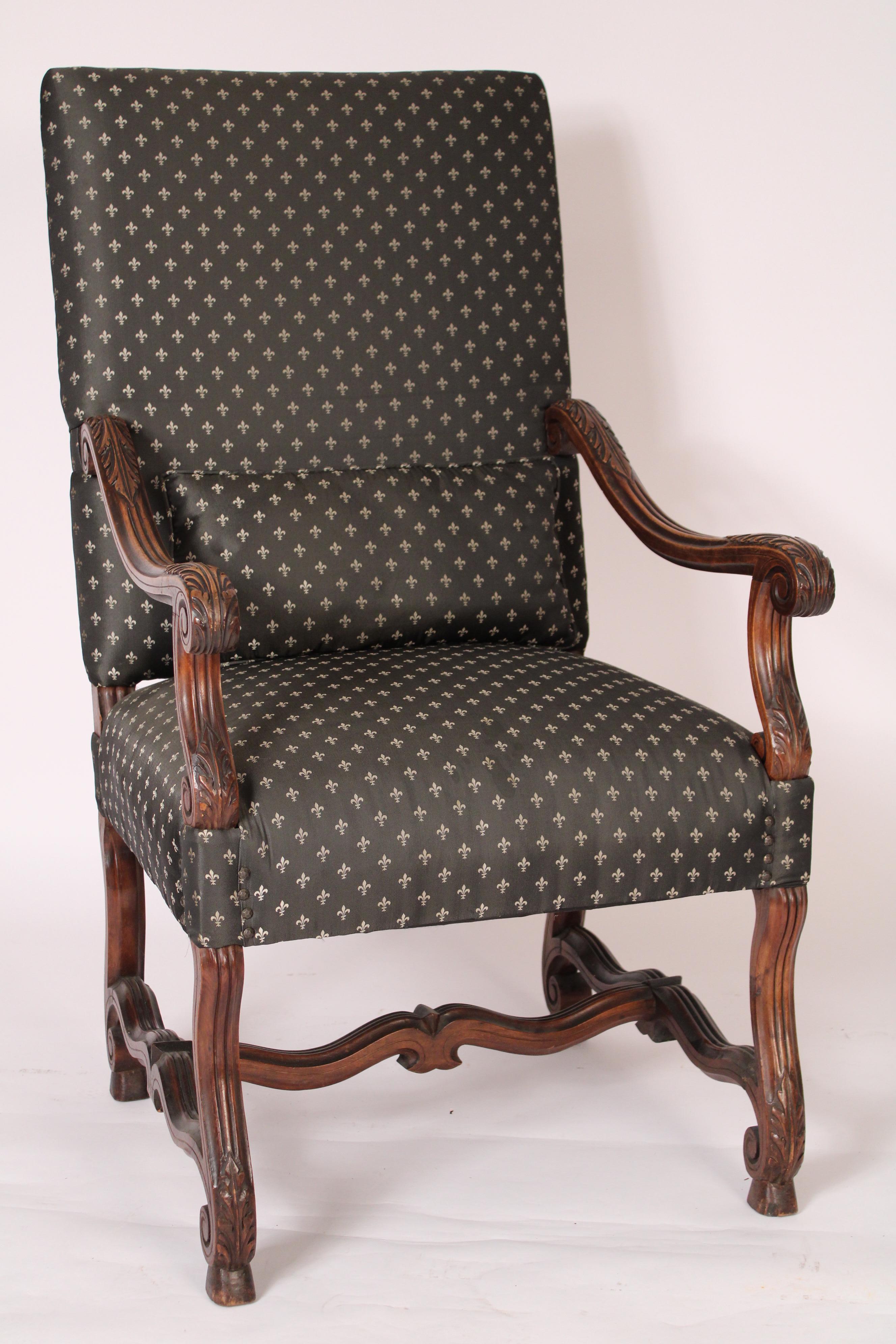 Paire de fauteuils en noyer sculpté de style Louis XIV, vers 1900. Les dossiers sont rembourrés et de forme rectangulaire, les accoudoirs et les supports d'accoudoirs sont en forme de serpentin sculpté d'acanthes, les pieds sont en forme de