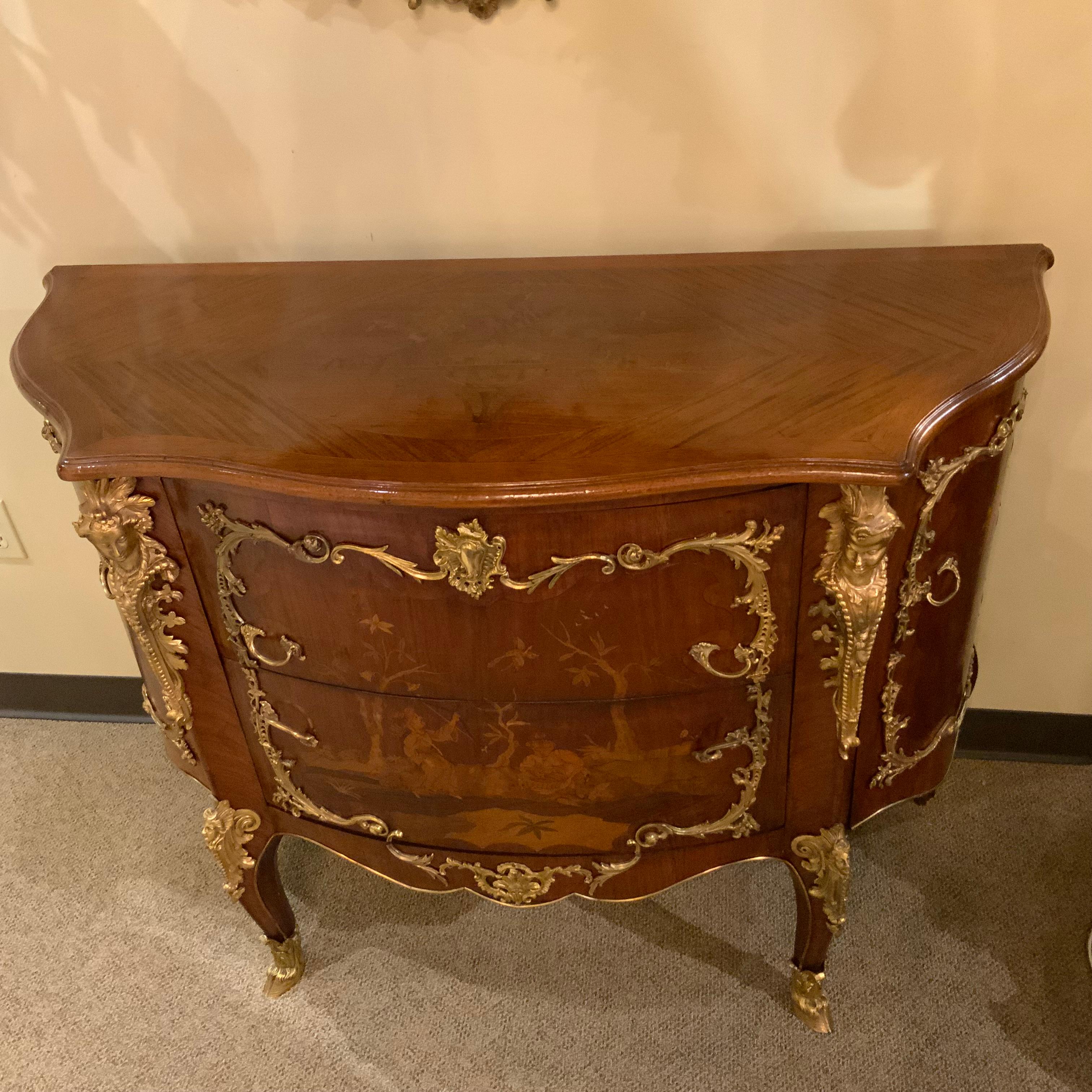 This pair of French commodes exhibit exceptional marquetry inlay
of the finest woods portraying a chinoiserie scene. It is late
19th century, each having a shaped and bowed top that is also
Inlaid with a floral and foliate oval motif above a