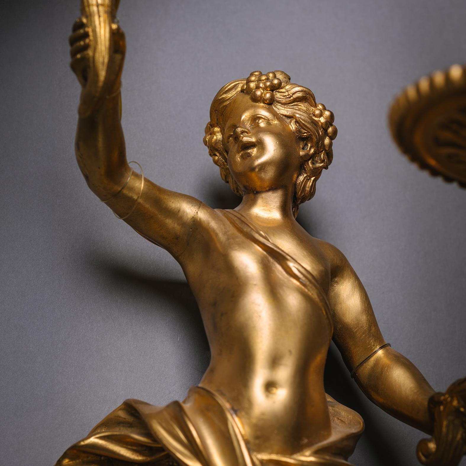 Paire d'appliques murales de style Louis XIV en bronze doré. À la manière d'André-Charles Boulle. 

Chacun d'entre eux est représenté sous la forme d'un hermès chérubin tenant en l'air des branches en spirale. Câblage pour l'électricité.

France,