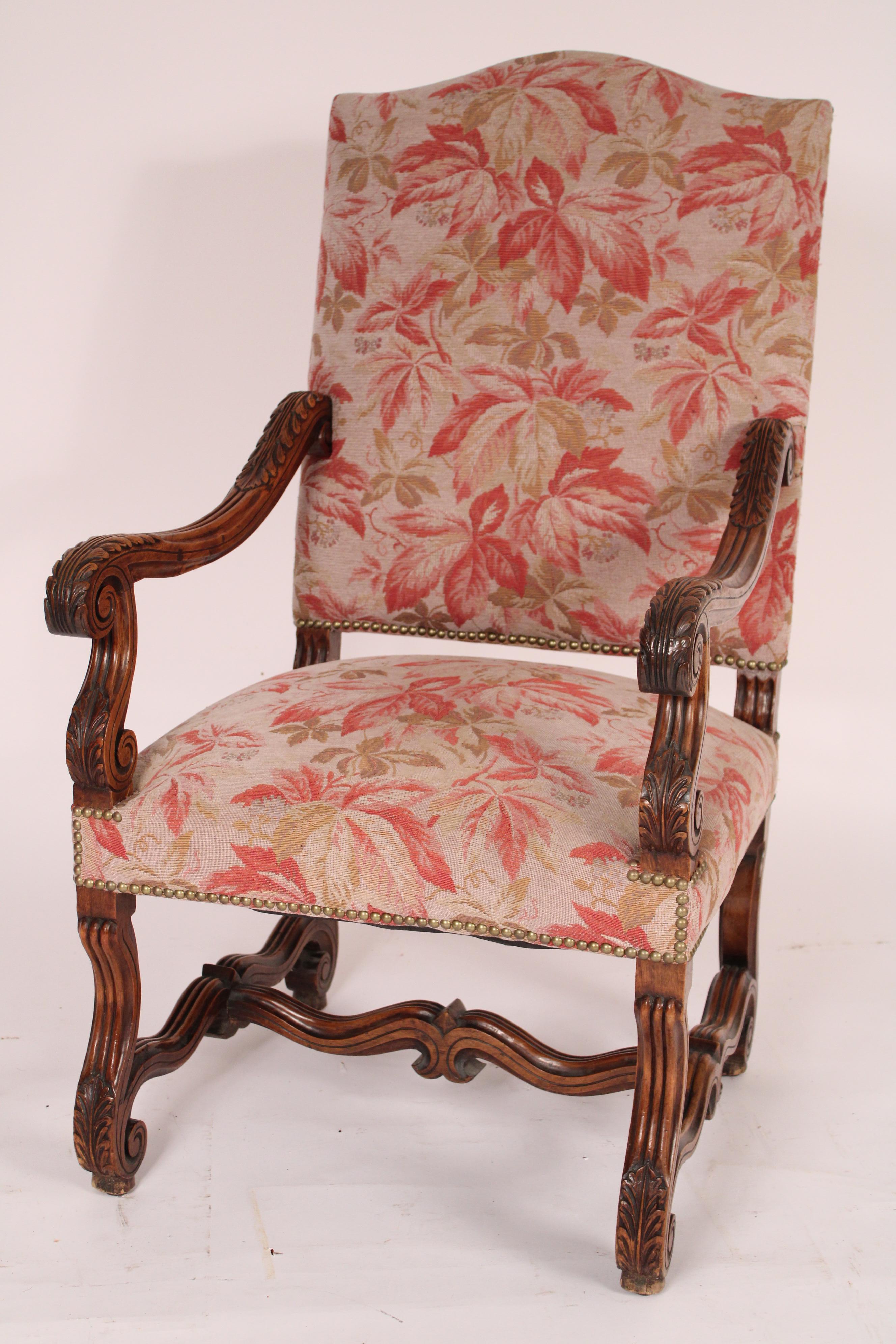 Pair of Louis XIV style carved walnut armchairs, circa 1910. With a cupids bow crest rail, serpentine acanthus carved arms, S shaped acanthus carved arm supports, legs and stretcher bars. The walnut has a nice old patina. Both chairs recently