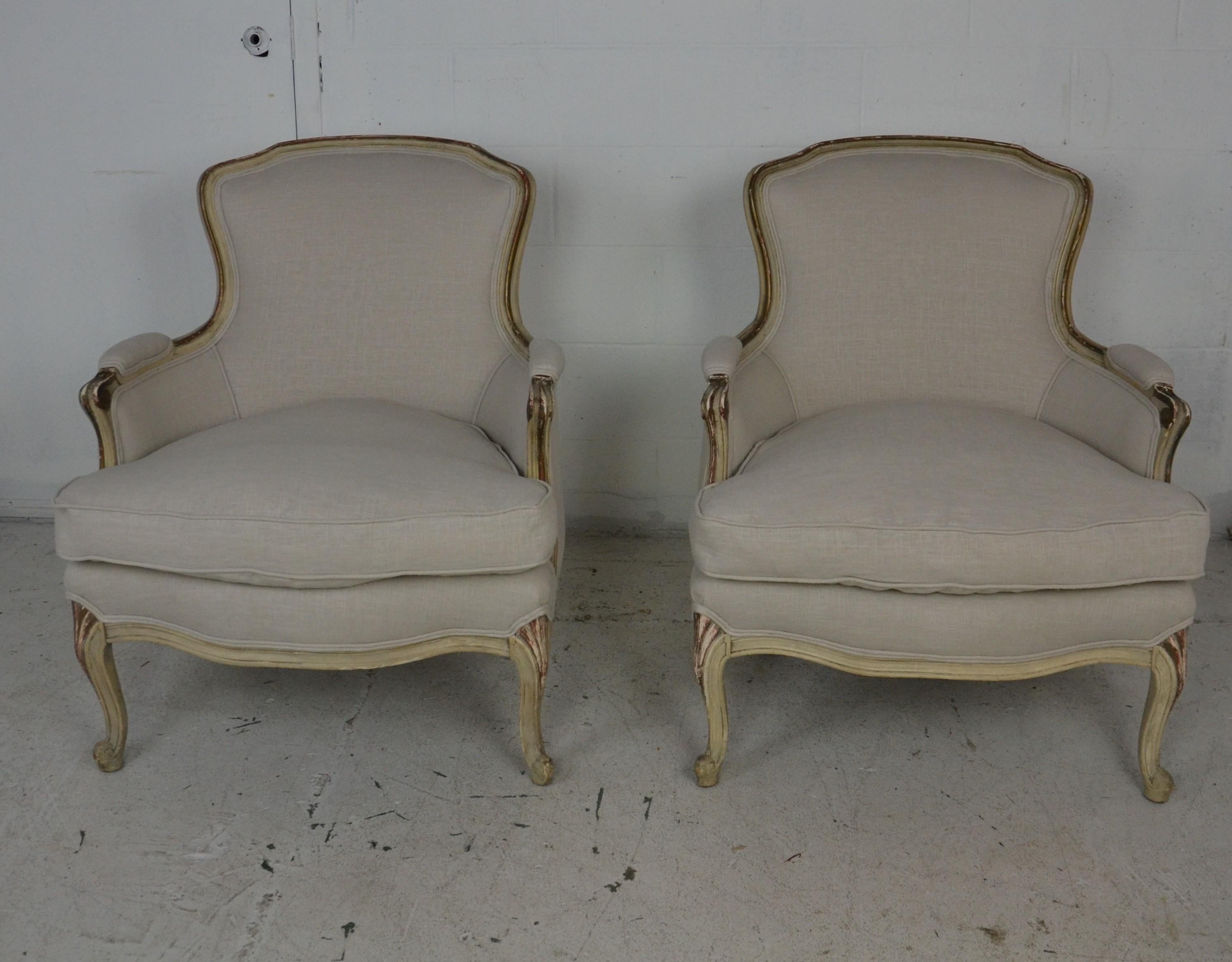 A pair of Louis XV Armchairs newly upholstered in a neutral gray linen. Frames with original old paint finish showing wear and fading.