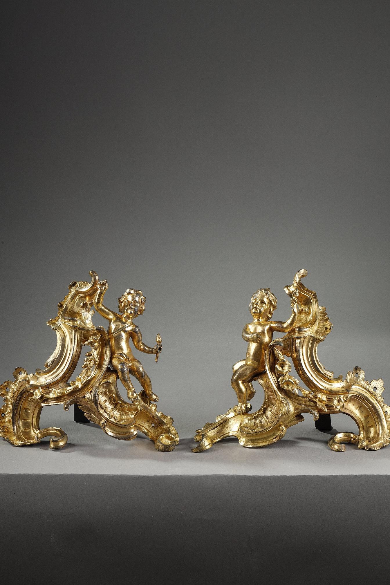 Beautiful pair of Louis XV period mercury ormolu andirons. The two symmetrical pendant putti are seated on leafy scrolls.

Andirons gave the opportunity to bronzemakers under Louis XV to display their utmost imagination, combining different rocaille