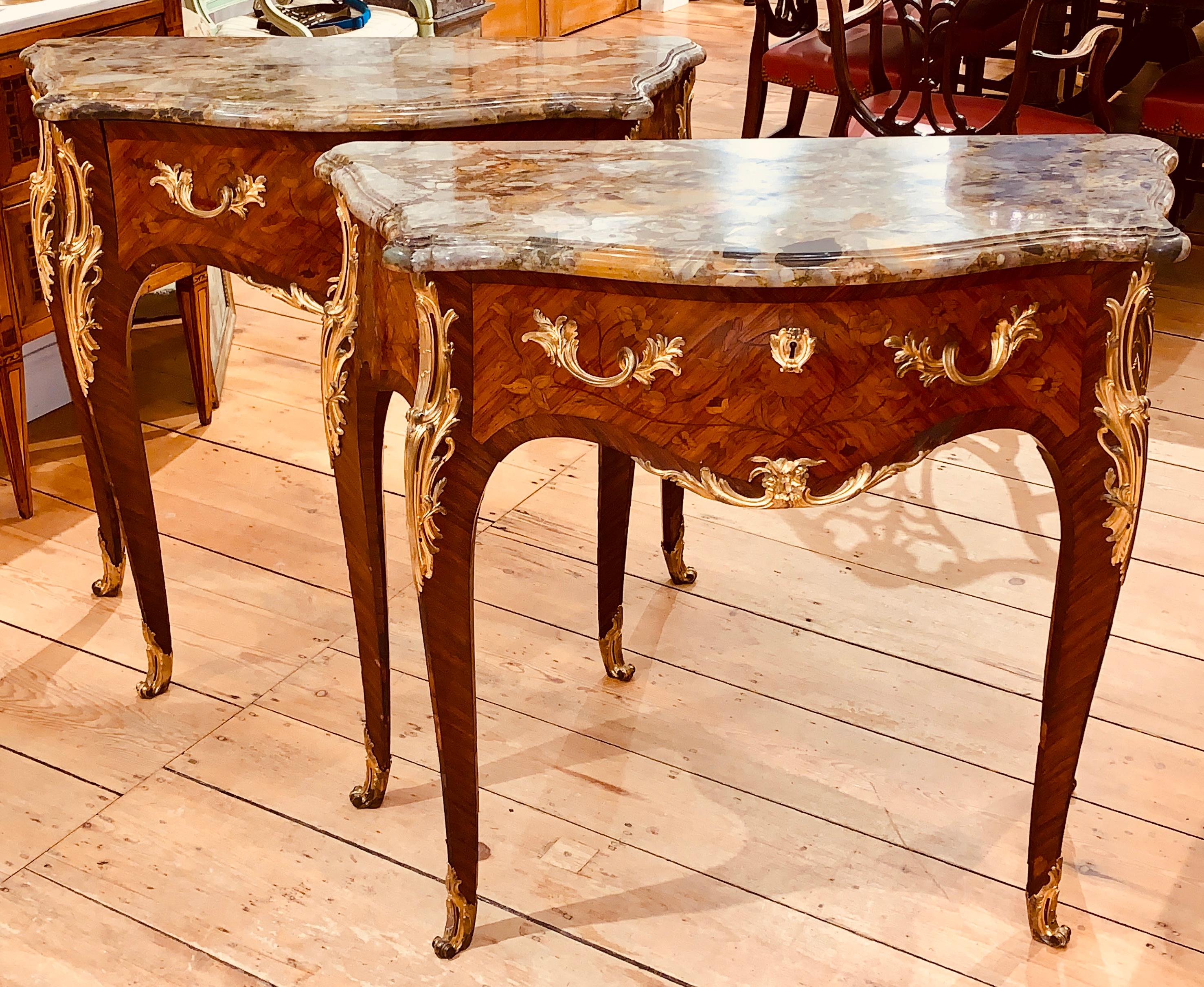 Pair of 19th century marble top and ormolu-mounted one drawer consoles or commodes.
Exquisite original molded marble tops over marquetry inlaid one drawer consoles. Cabriole legs, original ormolu mounts. Louis XV Style of the highest