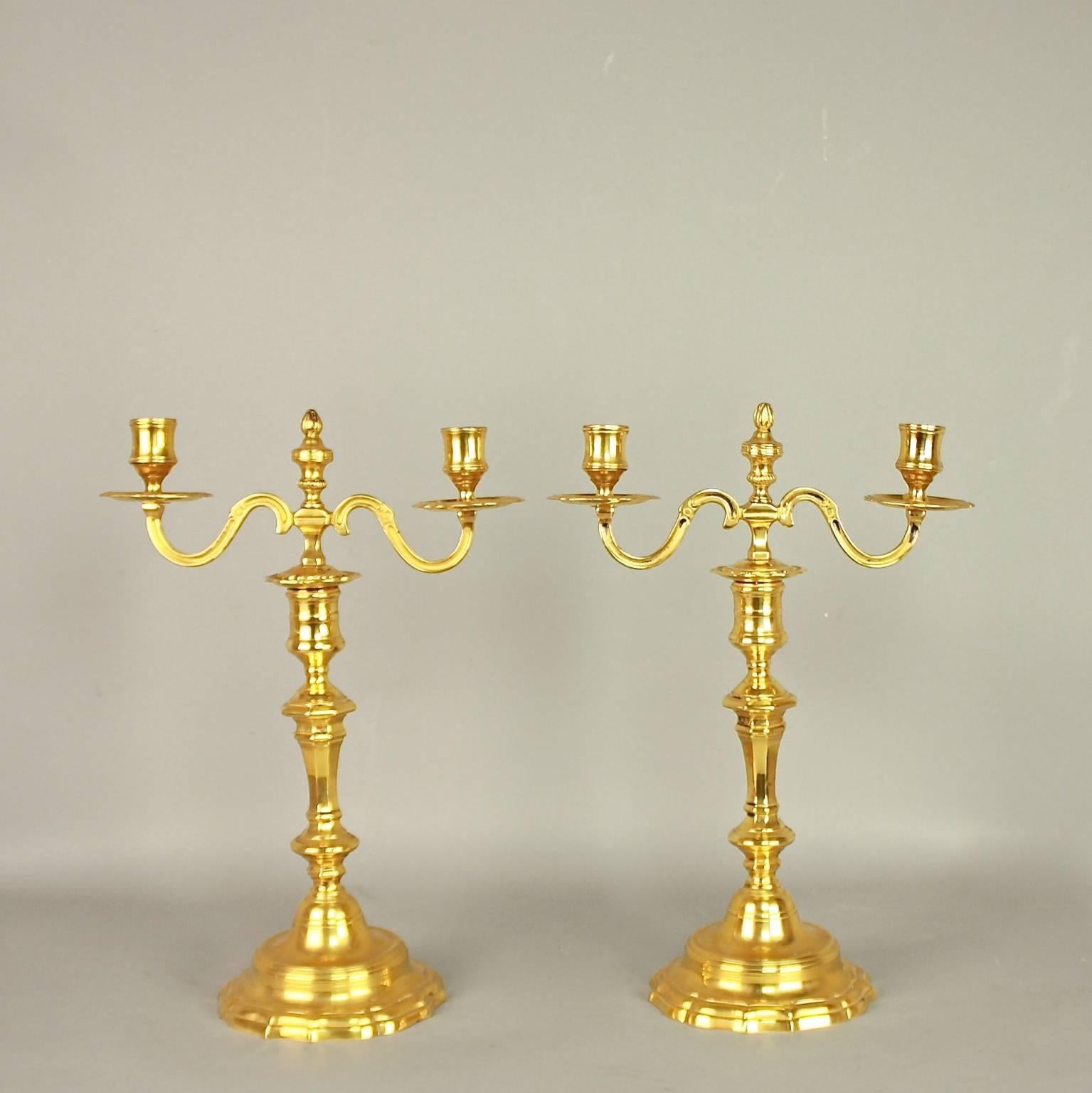 A fine pair of Louis XV ormolu two-light candelabra on a shaped circular base with a tapering octagonal stem and a baluster finial, issuing two scrolled arms supporting cylindrical sockets. The top part consisting of candle arms and finial removable