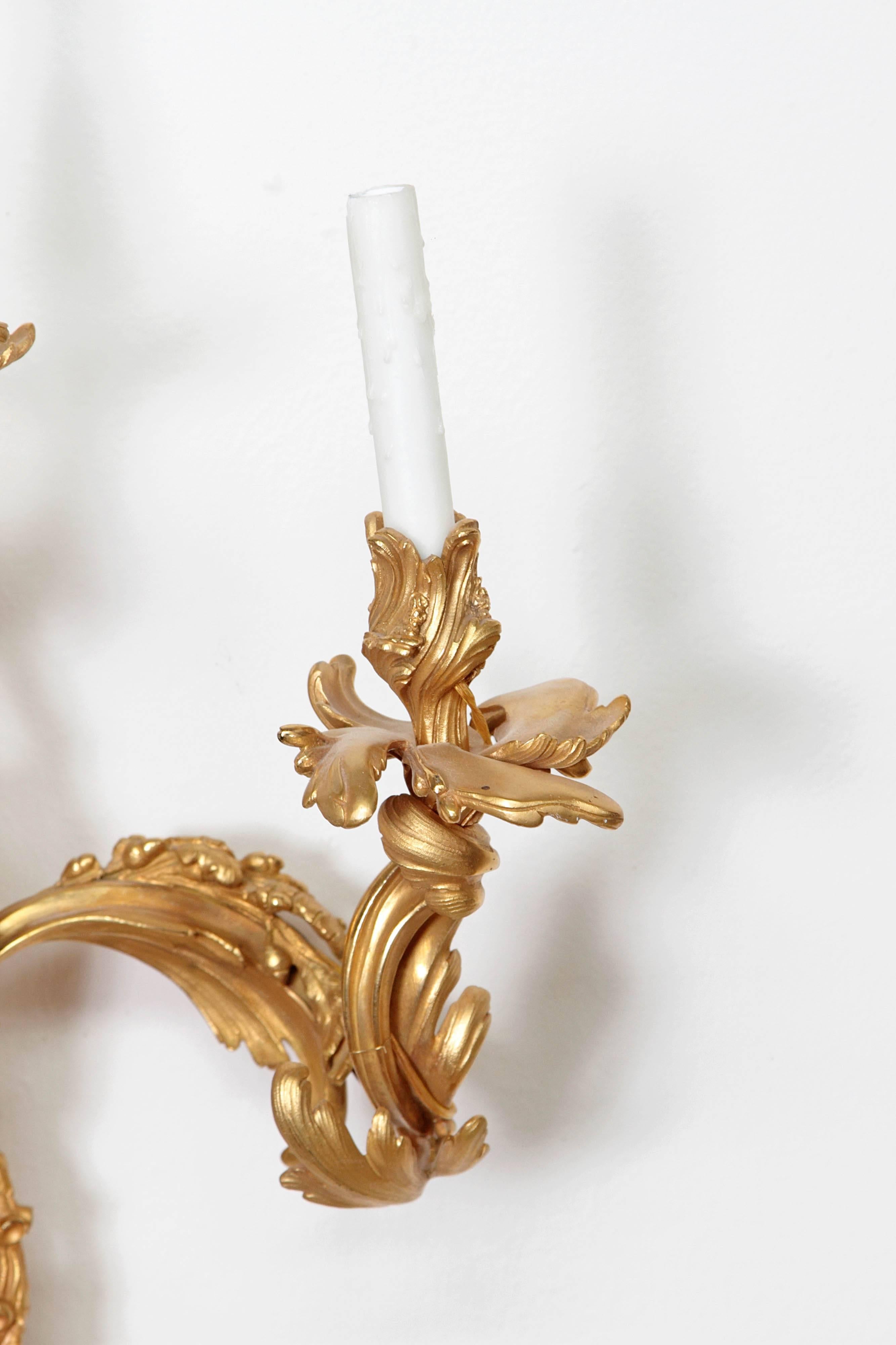 A pair of Louis XV-style doré bronze sconces, mercury gilded, burnished, foliate form, three lights with a putto at the base of each sconce. 19th century, circa 1880, France.

30