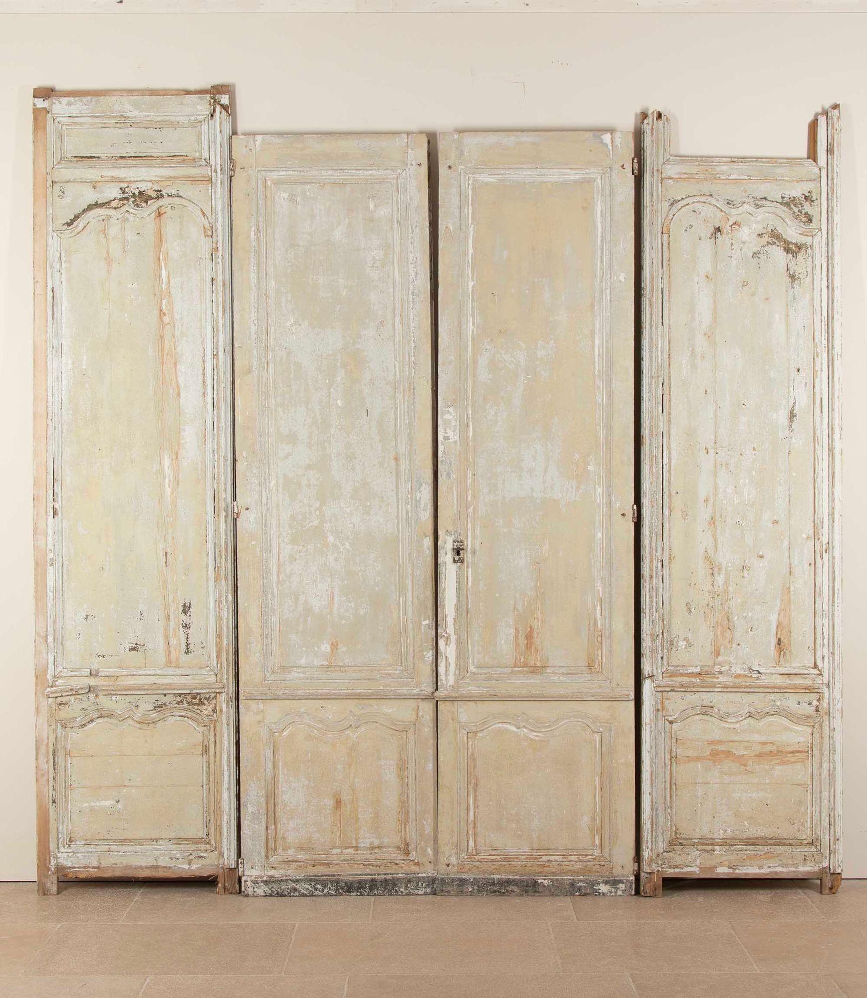 Un par de puertas francesas del siglo XVIII bellamente desgastadas por el tiempo y acompañadas de sus paneles laterales de boiserie originales, extraídas de un interior de época y que conservan una superficie patinada maravillosamente auténtica. El