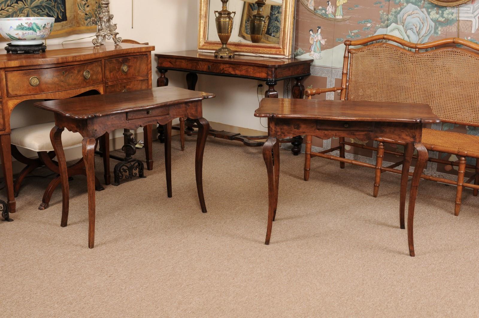 The pair of Italian Rococo console tables with serpentine tops and shaped apron ending cabriole legs.
