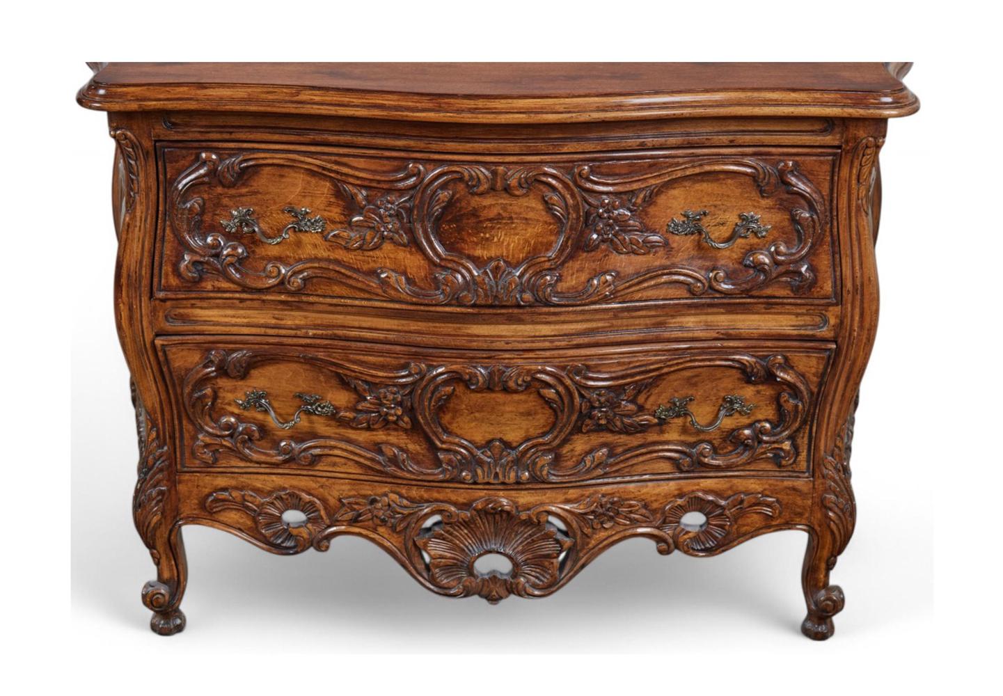 excellent quality reproductions, each with serpentine shaped top above a conforming bombe-form body fitted with two drawers over a pierced rocaille-carved apron all raised on scrolled supports; the drawer fronts with graceful hand-carved surface