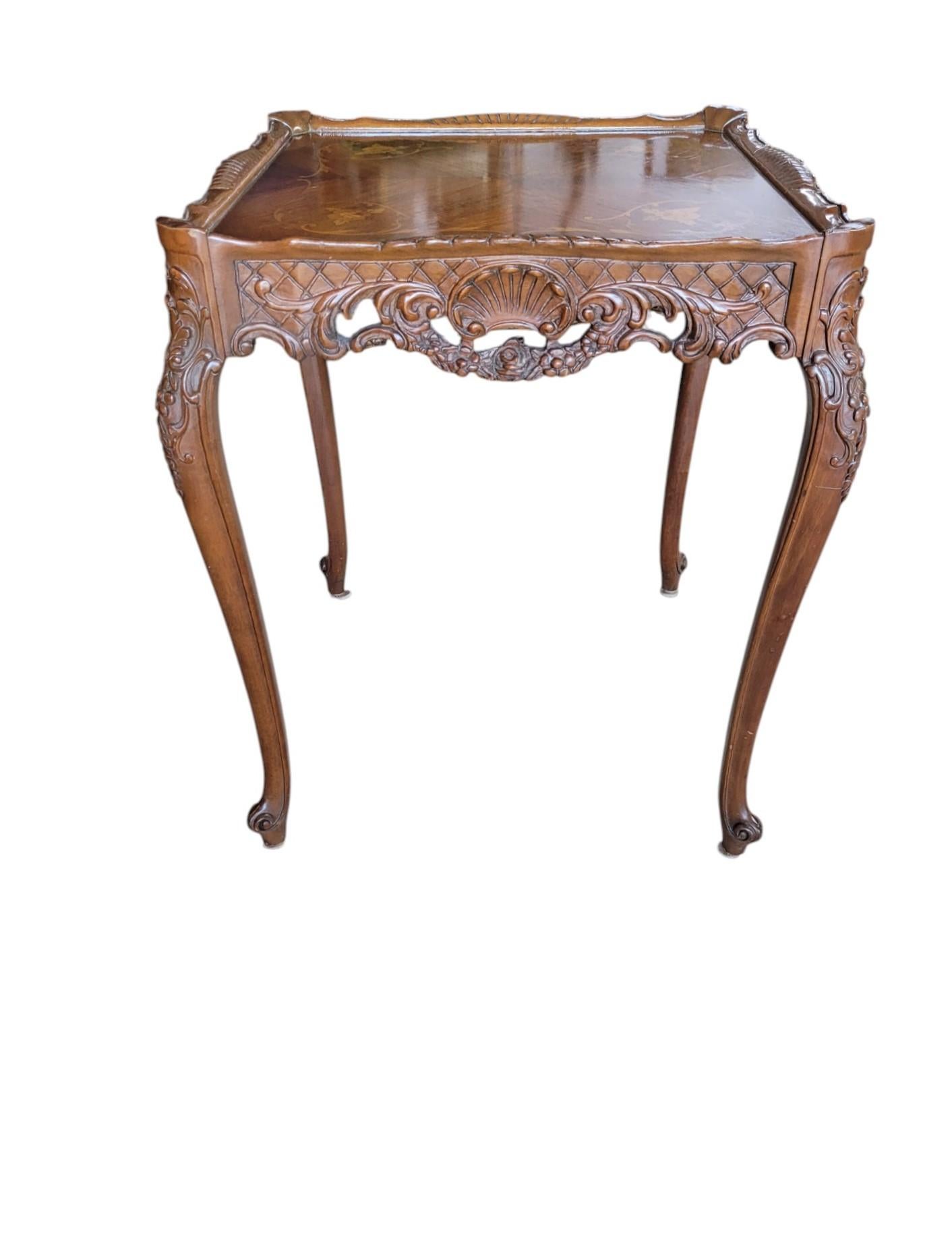 Cette paire de tables d'appoint de style Louis XV incarne l'élégance française, avec ses pieds cabriole gracieusement incurvés, ses tabliers richement sculptés et ses silhouettes serpentines fluides. Chaque plateau de table est orné d'une