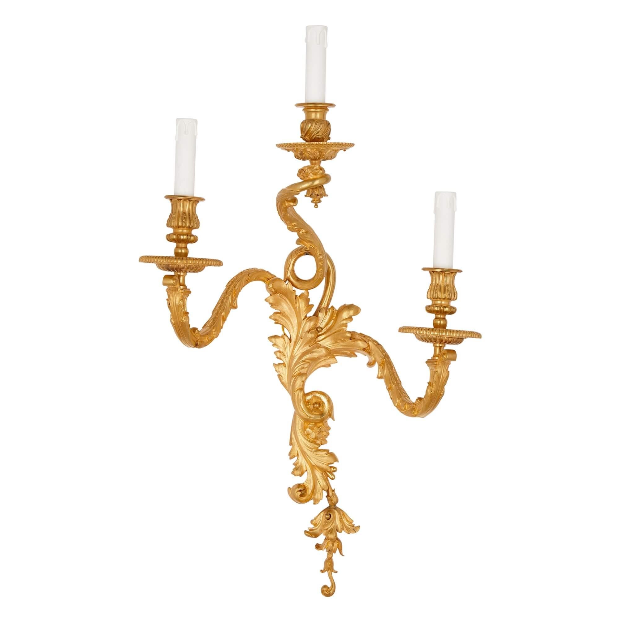 Pair of Louis XV Rococo style gilt bronze wall sconces.
French, late 19th century.
Measures: height 77cm, width 44cm, depth 24cm.

The two wall lights in this pair are crafted from gilt bronze in the Rococo style of Louis XV. Each light features