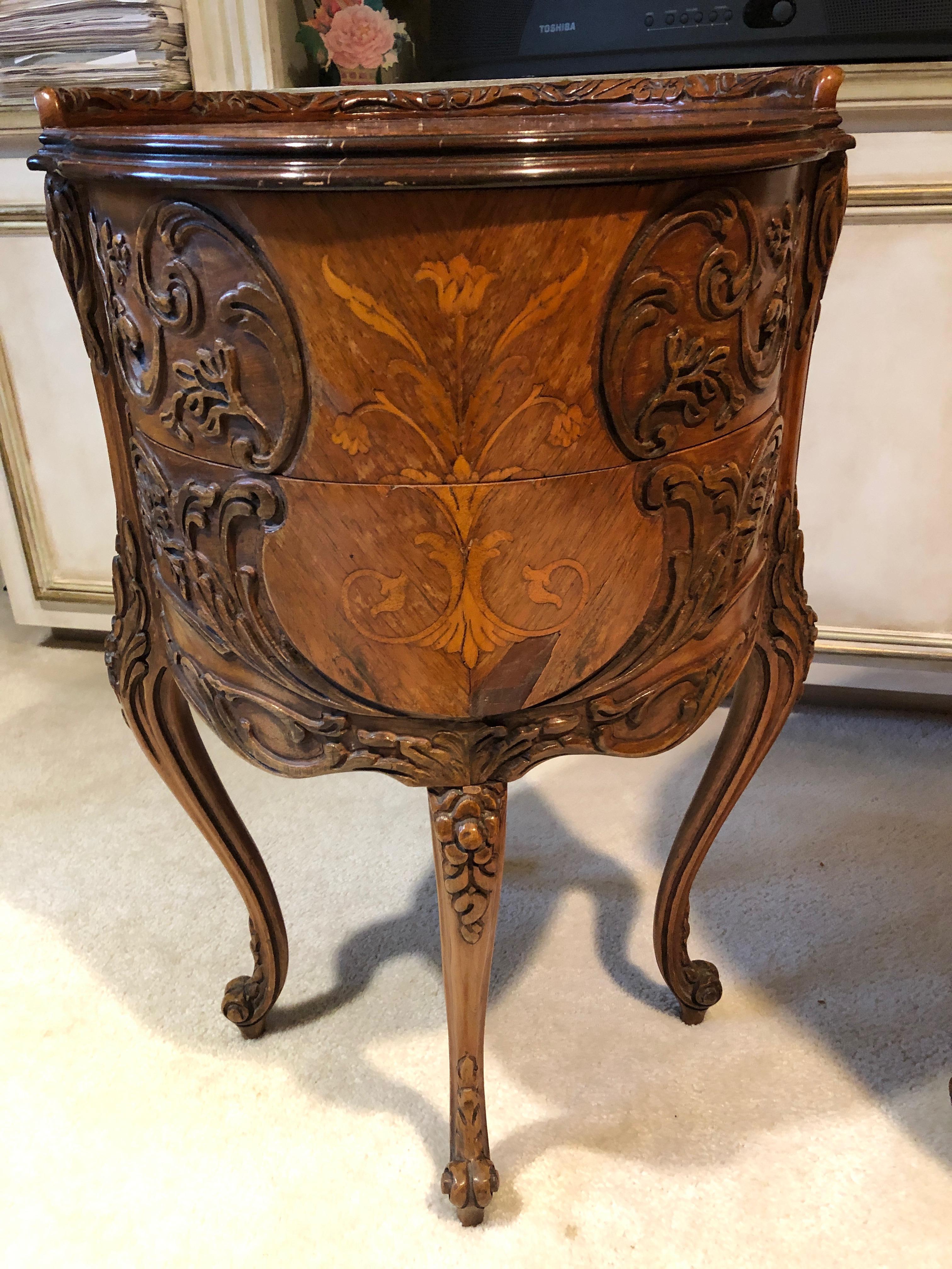 A rare pair of lovely round nightstands having a carved partial gallery, inlaid marquetry top and front panel, scroll and folitate relief carved sides with single drawer on cabriole legs with floral relief carved knees, and terminating in scroll