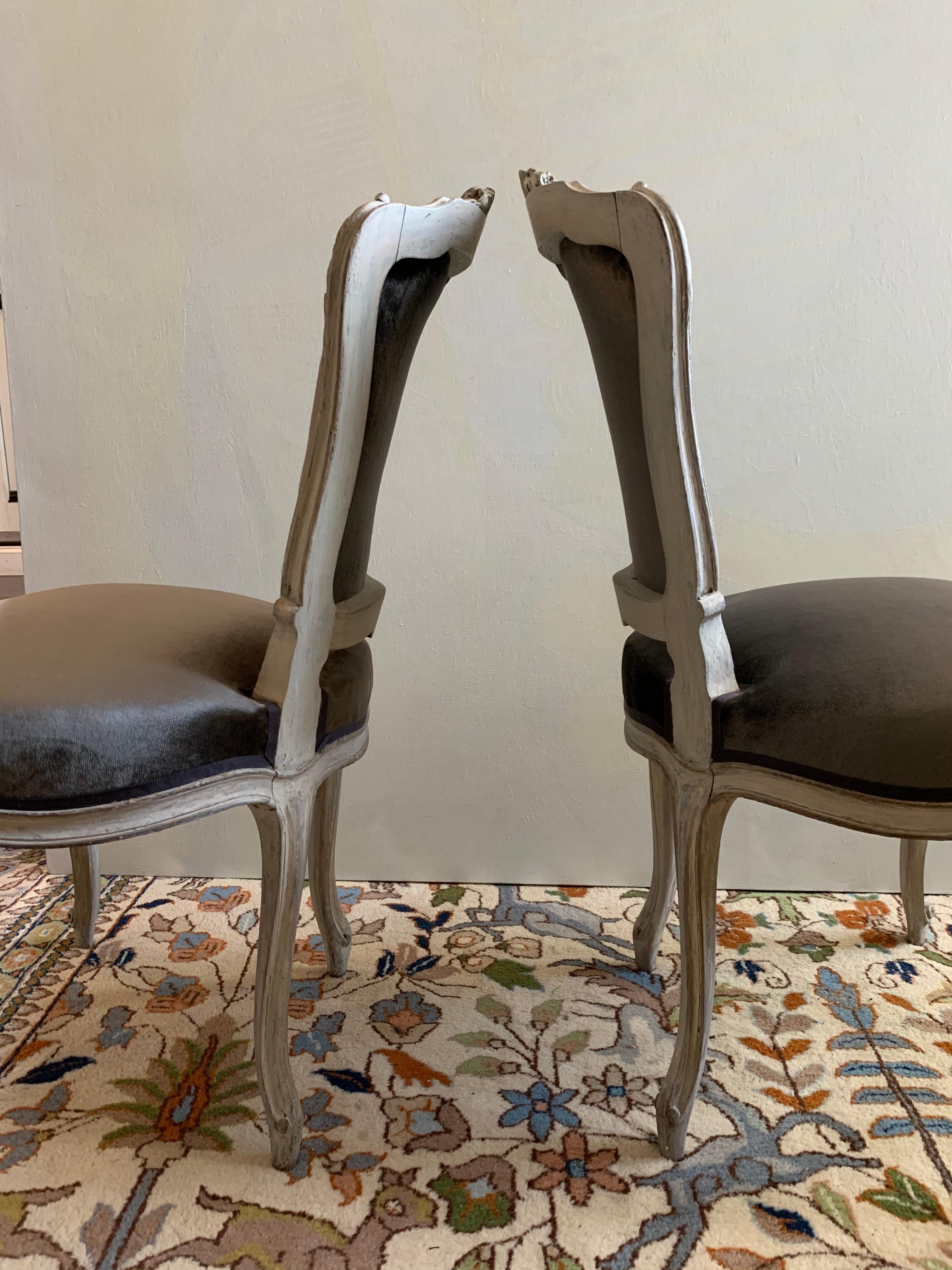 A pair of Louis XV style side chairs, nicely carved frames with a whitewashed finish, recently upholstered in a grey silk velvet, early 19th century.