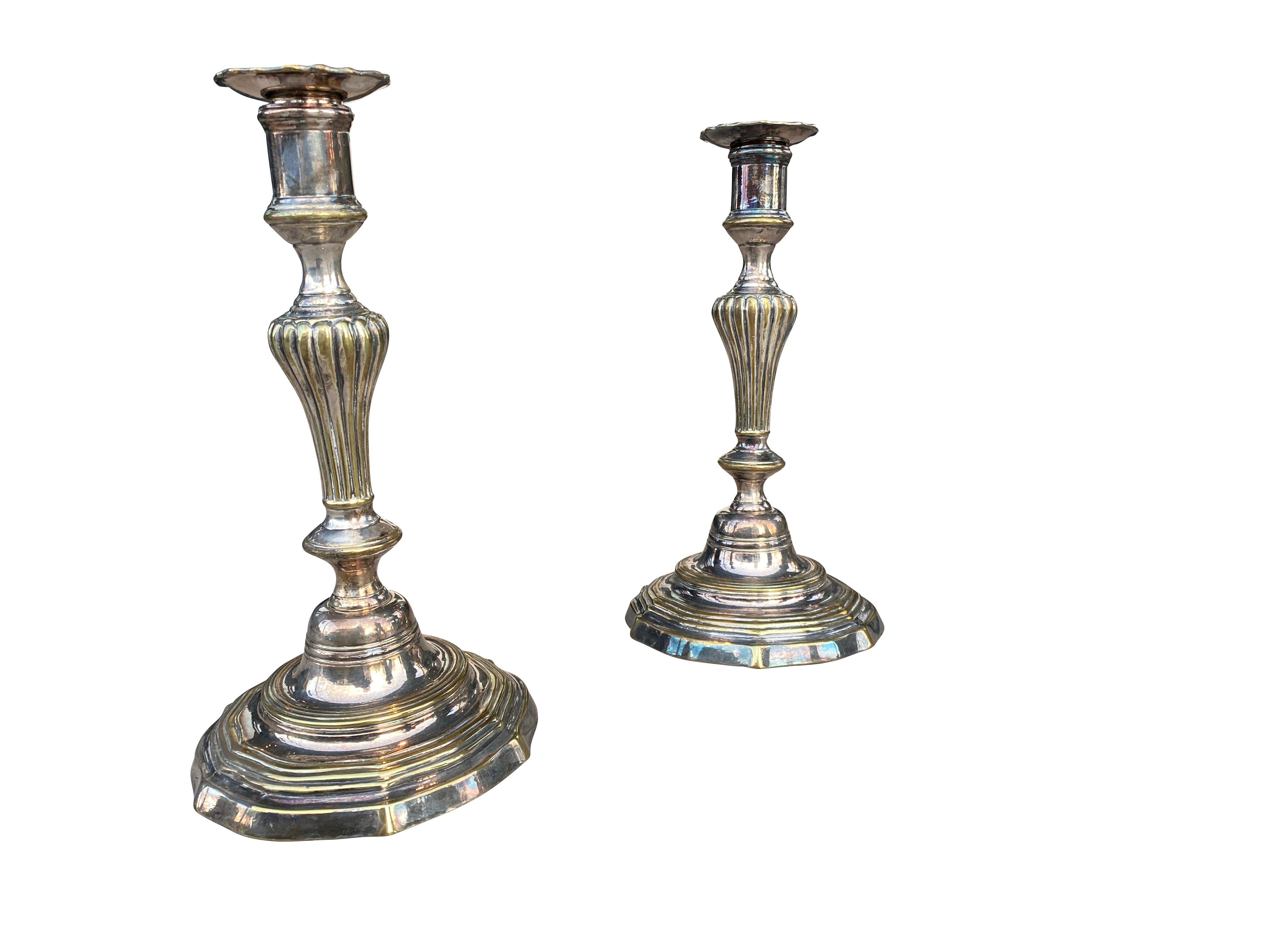 Each with bobeches, reeded baluster form and shaped circular stepped base.