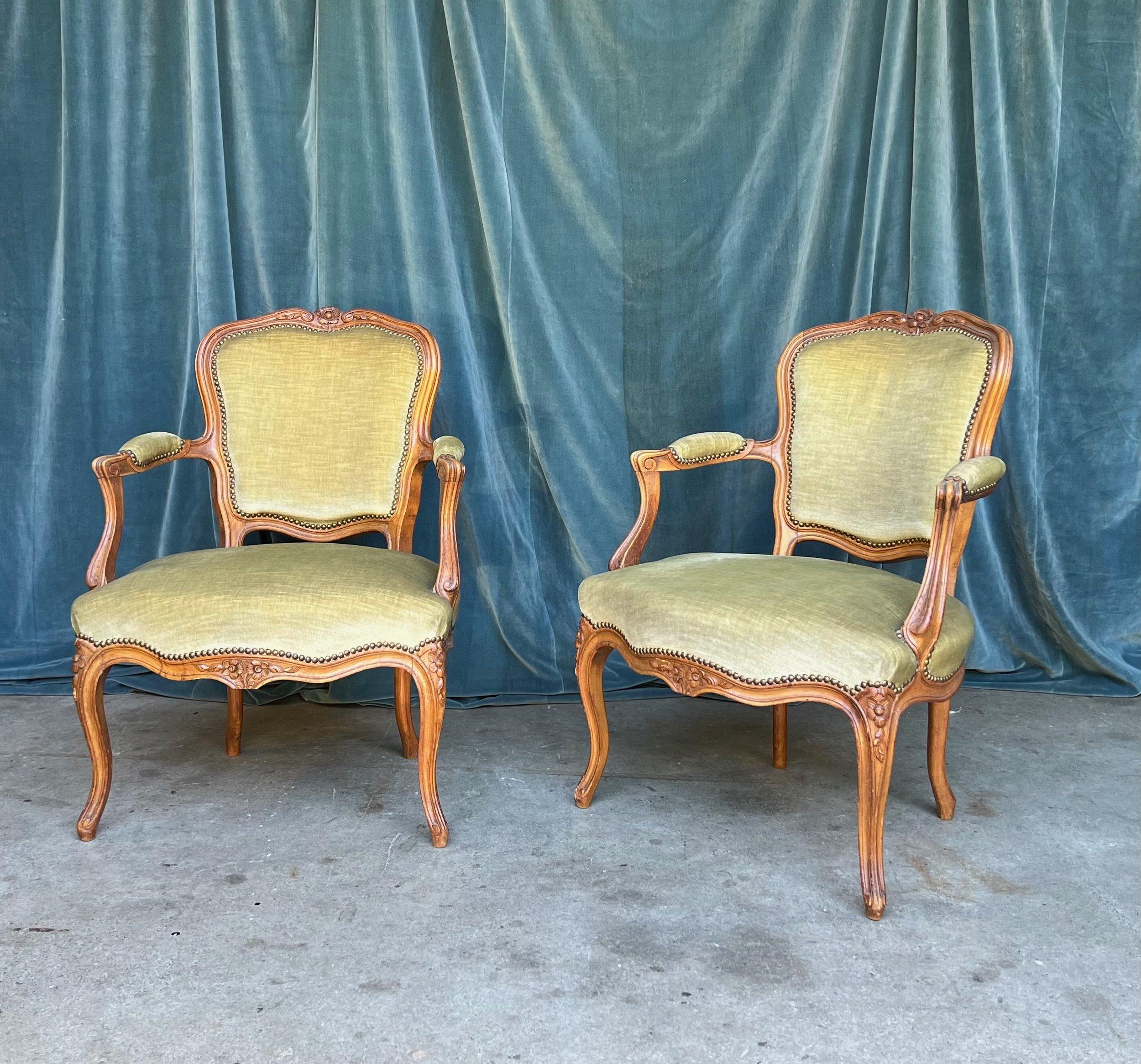 Cette élégante paire de fauteuils en bois fruitier de style Louis XV, tapissée d'un doux et délicat velours vert pâle, ajoutera une touche d'élégance à tout salon ou bureau. Les sculptures complexes des cadres imitent les décorations florales que