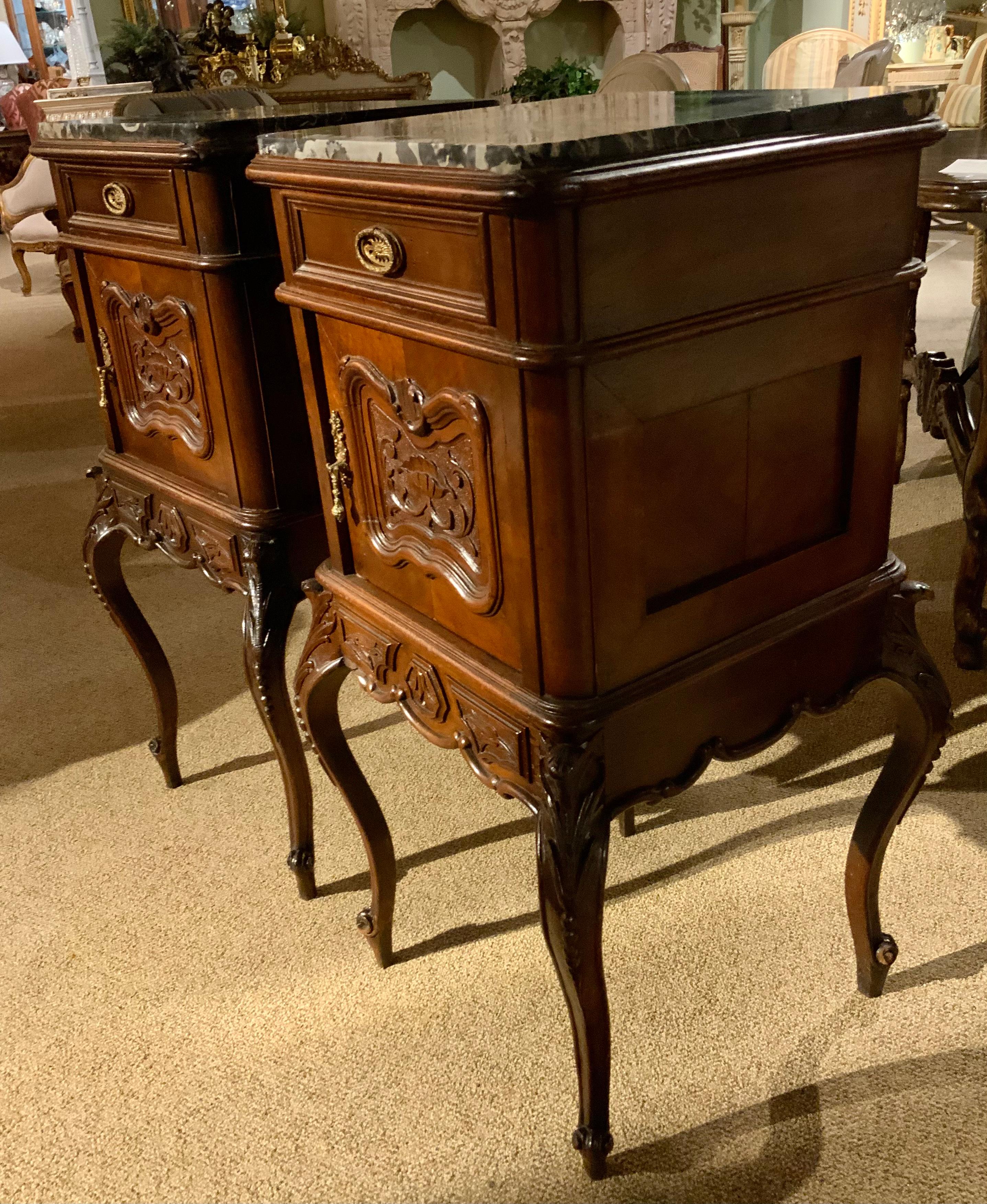 Pair of walnut bedside cabinets with exceptional carving and a black  and
Gold marble top. The cabriole legs are gracefully carved on both the
Front and back. The hardware is original and very well done.  The doors
And drawers open easily and have