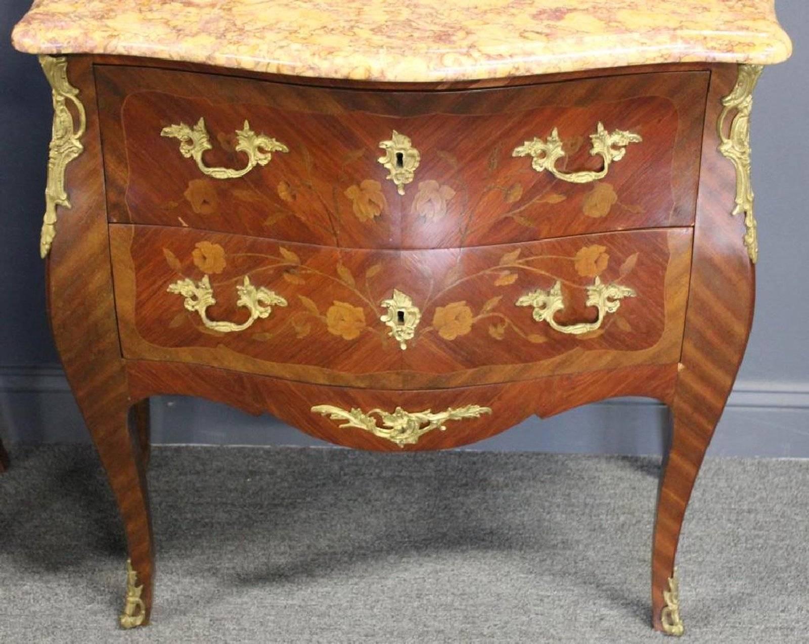 A lovely pair of Louis XV style bronze-mounted marble-top commodes.
Floral marquetry throughout. Two drawers, and great size.