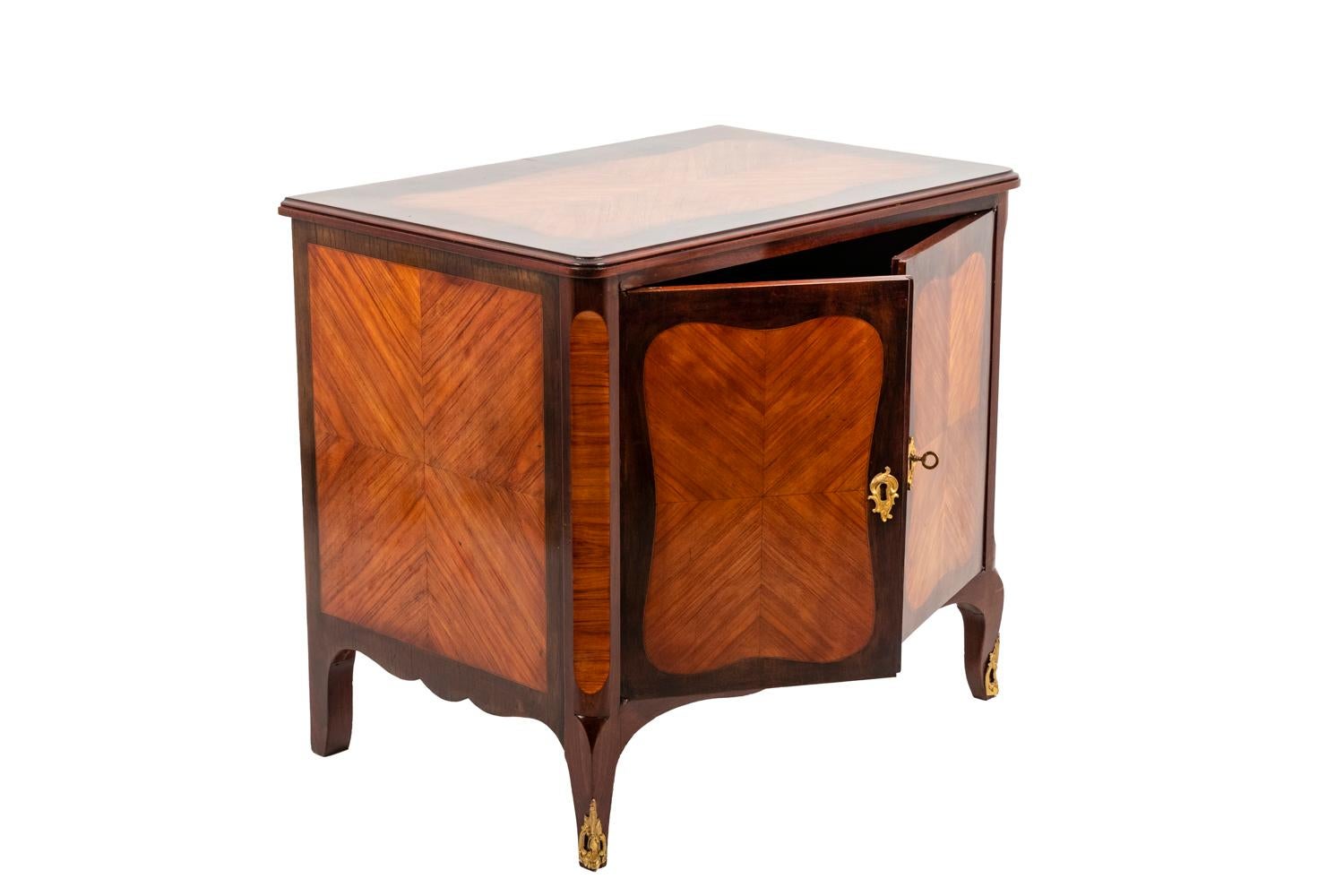 Pair of Louis XV buffets in kingwood standing on four cabriole legs opening by to leaf doors on a compartment with a shelf. Cabriole-shaped apron. Straight tray. Beveled angles. Cartouches of rosewood on the two leaf doors, the angles, the flanks
