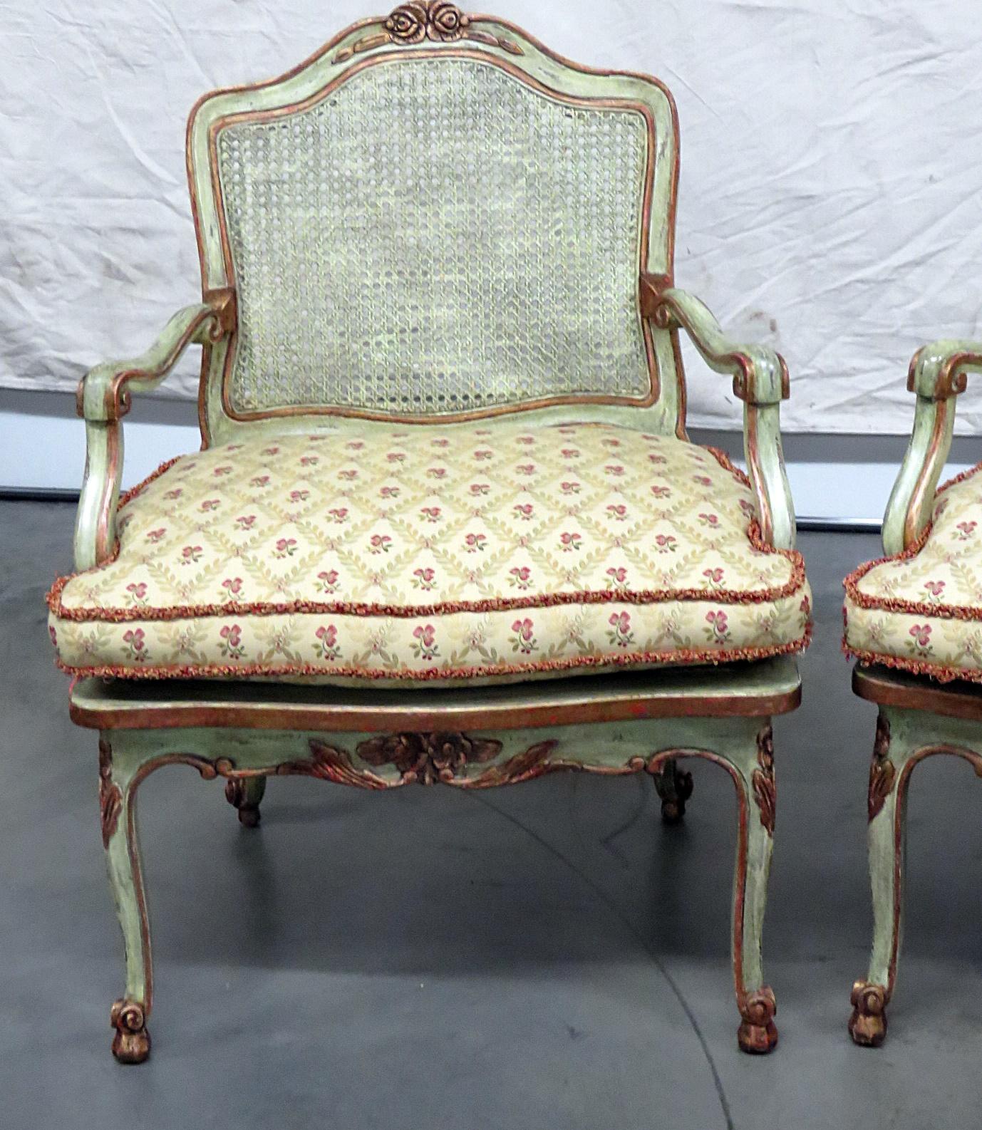 Pair of Louis XV style distressed painted armchairs with caned seats and backs with removable cushions.