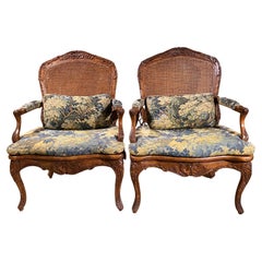 Paire de fauteuils de style Louis XV en bois fruitier canné avec tissu d'ameublement