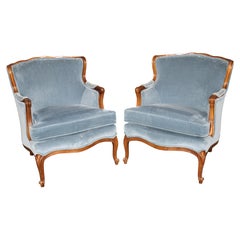 Paire de fauteuils bergère sculptés de style Louis XV, avec revêtement bleu