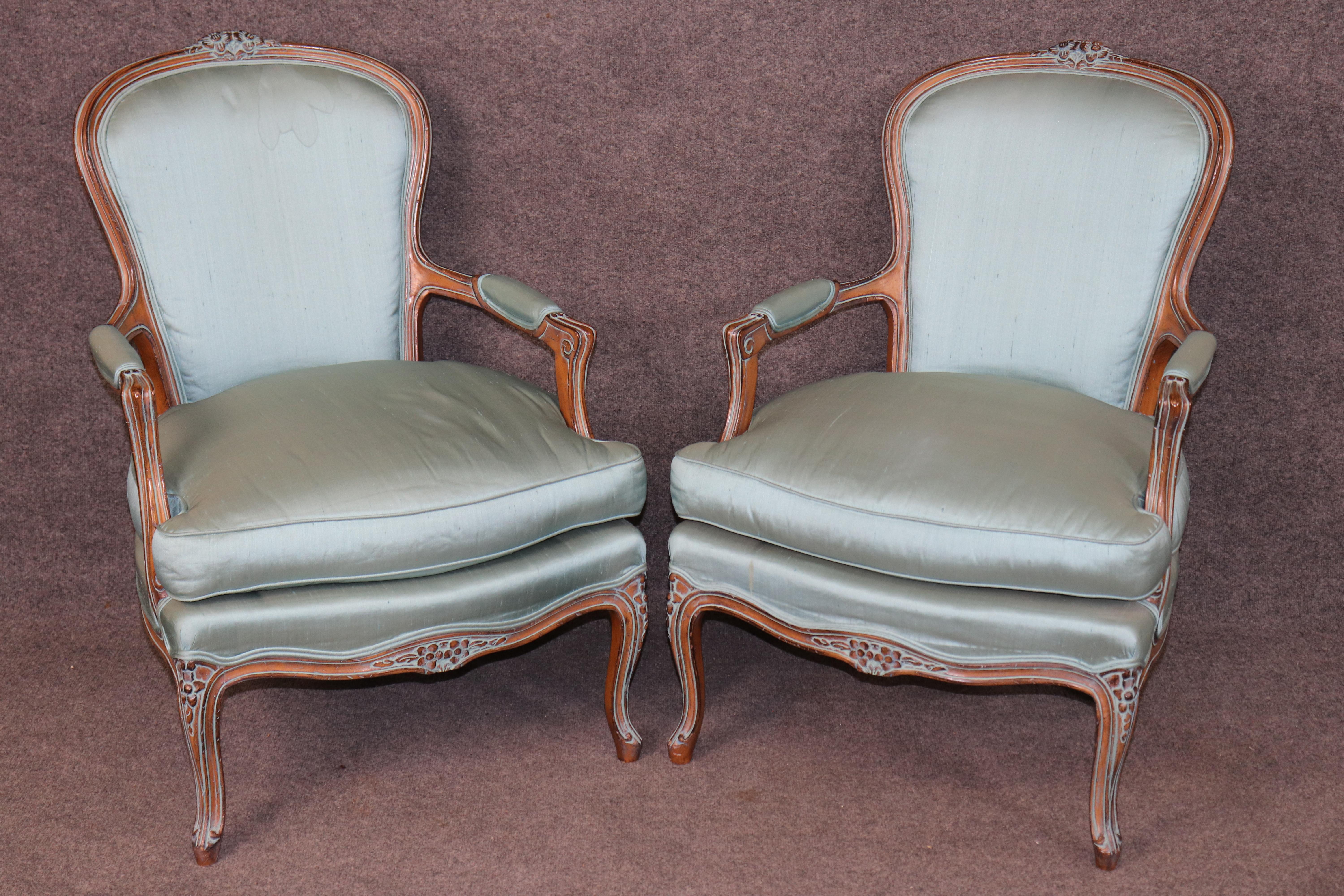 Dimensioni - H. H. 37 pollici W: 26 1/2 in P: 28 3/4 in SH: 20 in 

Questa splendida coppia di poltrone in noce intagliato in stile Luigi XV cattura l'essenza del classico design francese del XVIII secolo, esaltato da una finitura morbida e affilata