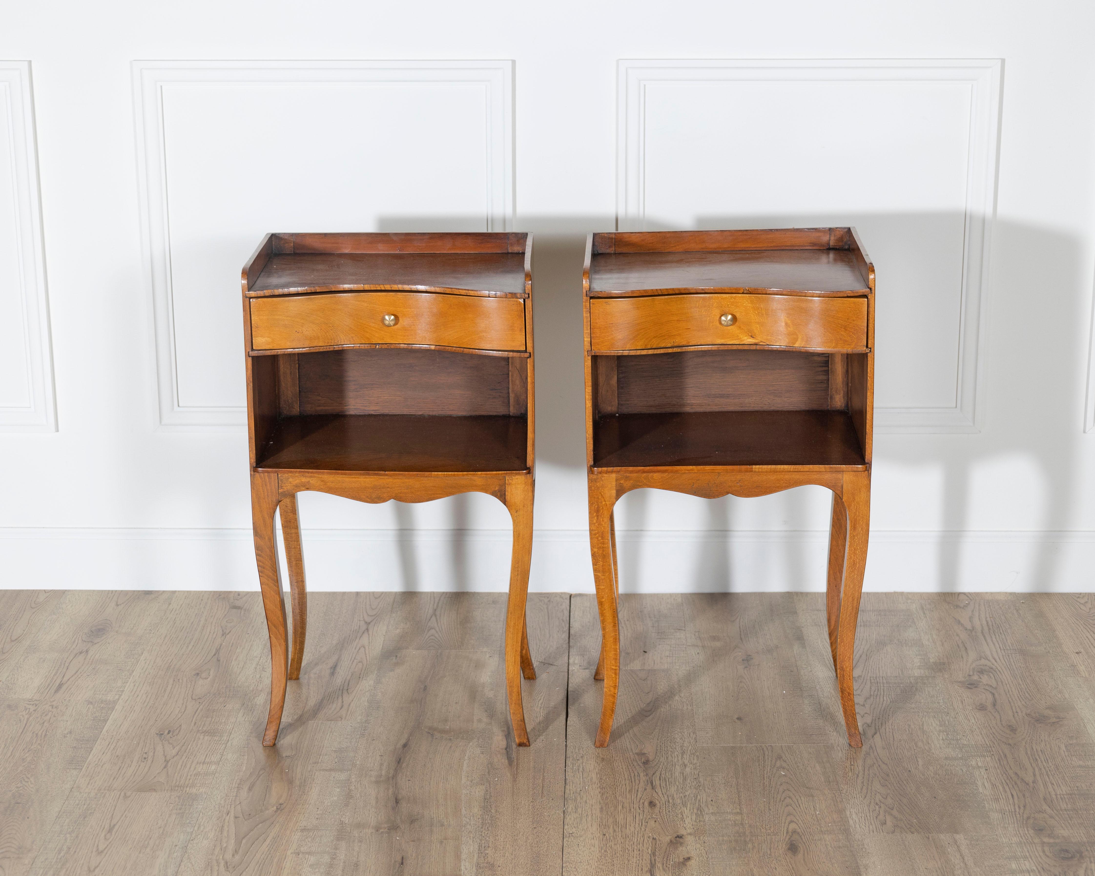 Questa affascinante coppia di comodini in stile Luigi XV cattura il calore e l'eleganza del design classico francese. Realizzato in legno di ciliegio e impiallacciatura di ciliegio, ogni tavolo è caratterizzato da una superficie splendidamente