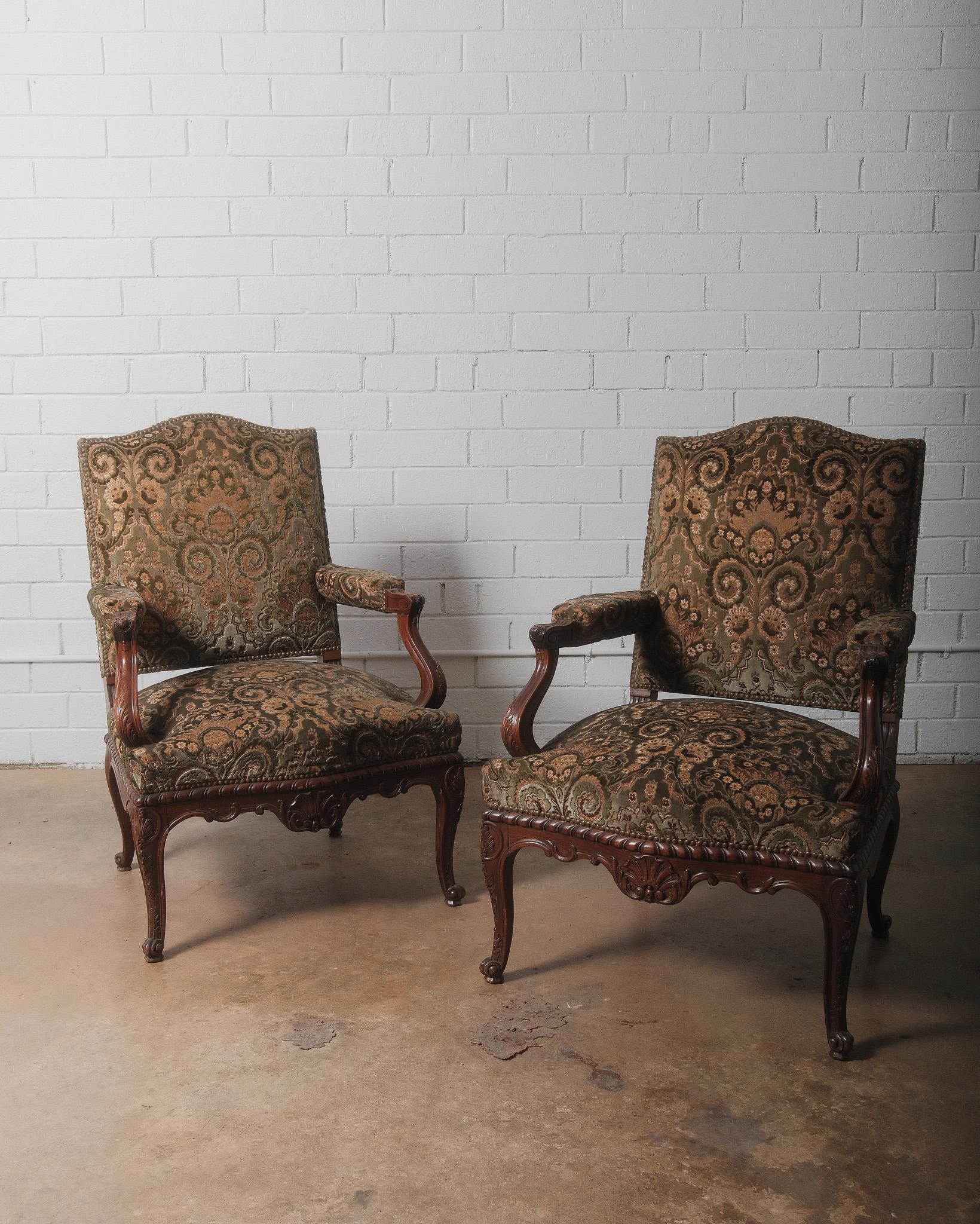 Questa elegante coppia di poltrone fauteuil in stile Luigi XV mostra il fascino senza tempo del design francese, probabilmente realizzato tra la fine del XIX e l'inizio del XX secolo. Le sedie presentano intricate strutture in legno intagliato con