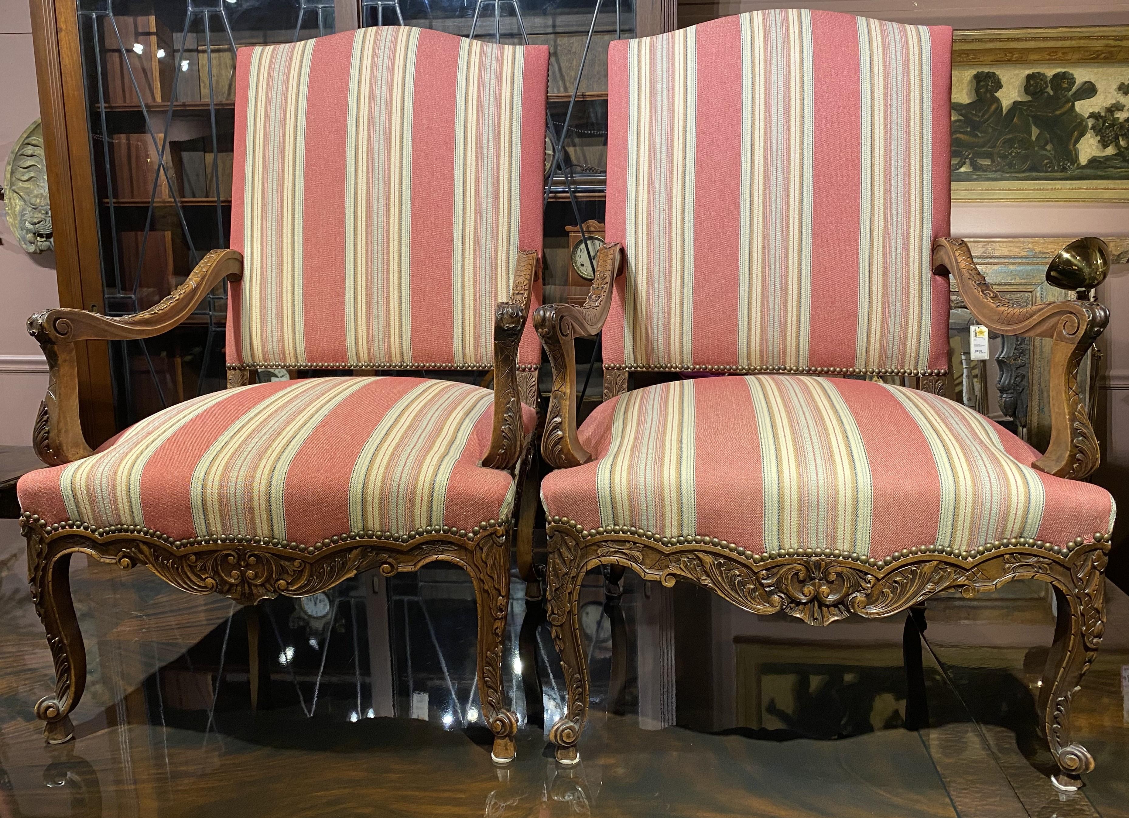 Una coppia di poltrone di qualità in legno di frutto in stile Luigi XV, con decorazioni intagliate a volute e fogliami ben dettagliati, arredate con tappezzeria a righe di Brunschwig & Fils e rifinite con chiodi in ottone per la tappezzeria. La