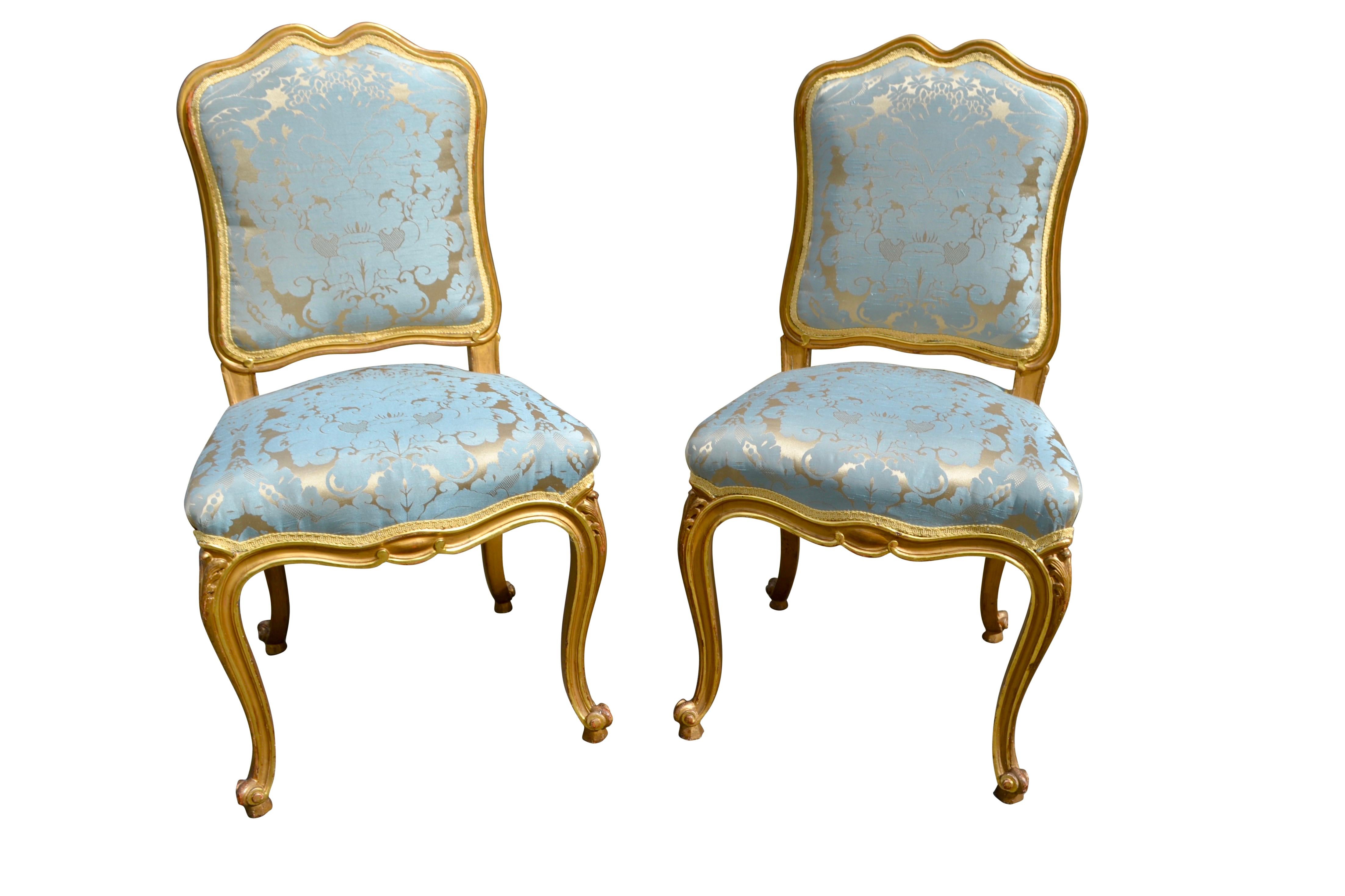 A decorative pair of Louis XV style side chairs, the well carved frames are finished in gold leaf and have recently been upholstered in a turquoise/gilt damask.