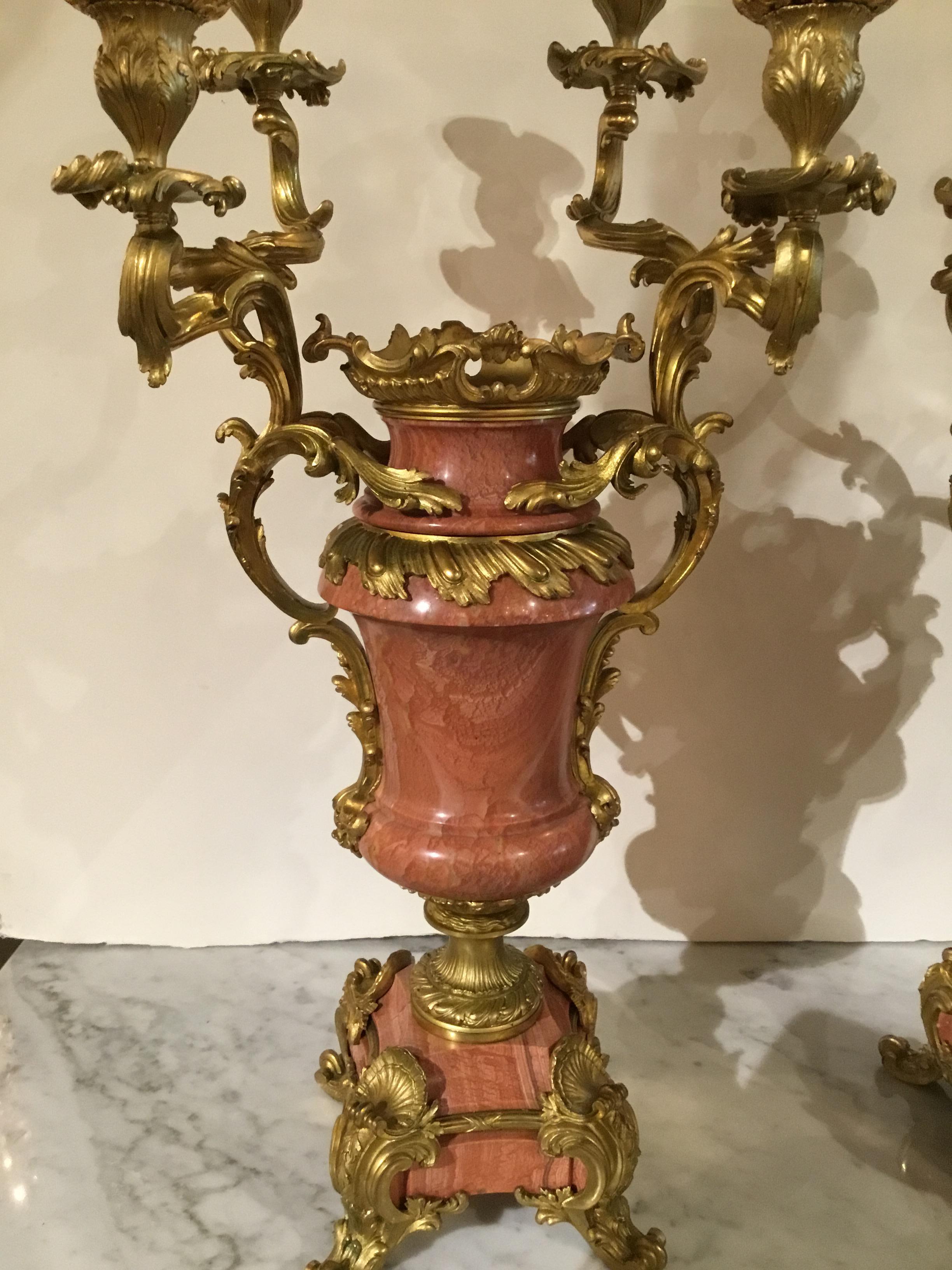 Pair of four-light bronze dore mounted pink marble candelabrum. Each of vasiform, flanked by
Scrolling acanthus cars handled issuing branches ending in bombe’ nozzles above a gadrooned
Collar on a circular foliate modeled so Le and raised on a