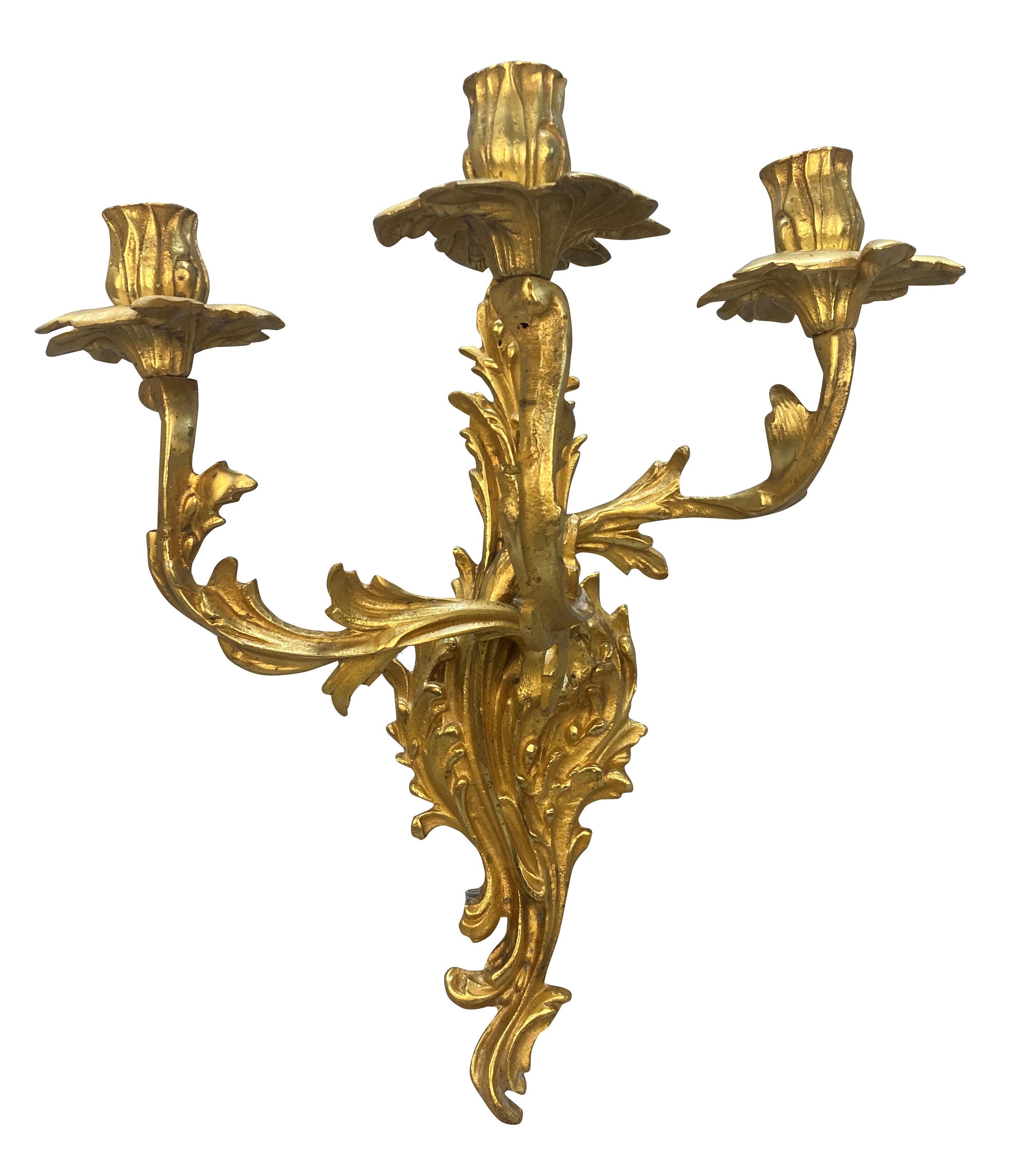 Pareja de apliques franceses de bronce dorado de tres brazos, estilo Luis XV. No electrificada.