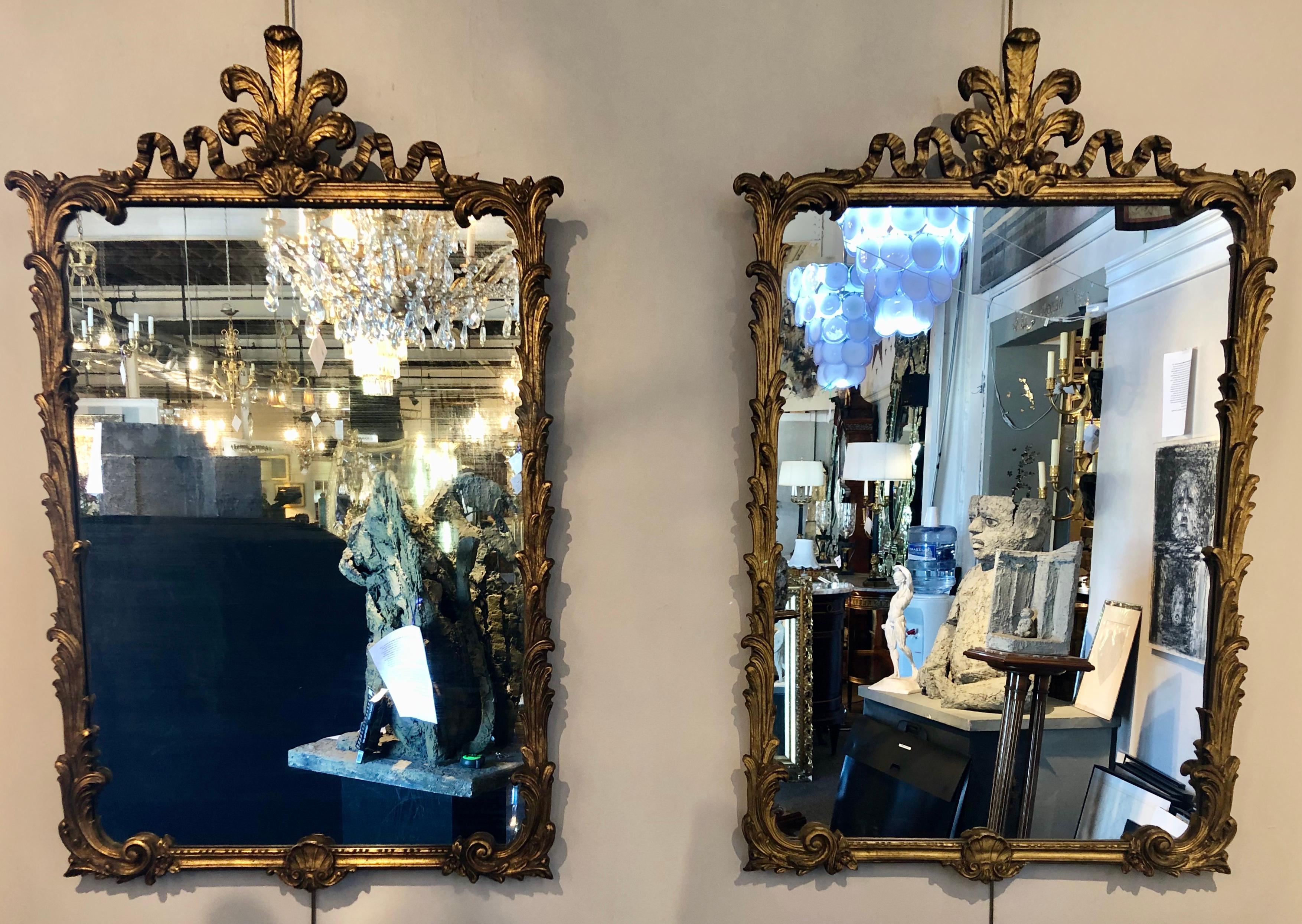 Pair of Louis XV style giltwood wall or console mirrors. Italian finely carved pair of giltwood mirrors with feather and leaf, floral rose design framing a center mirror.


ZSXX.