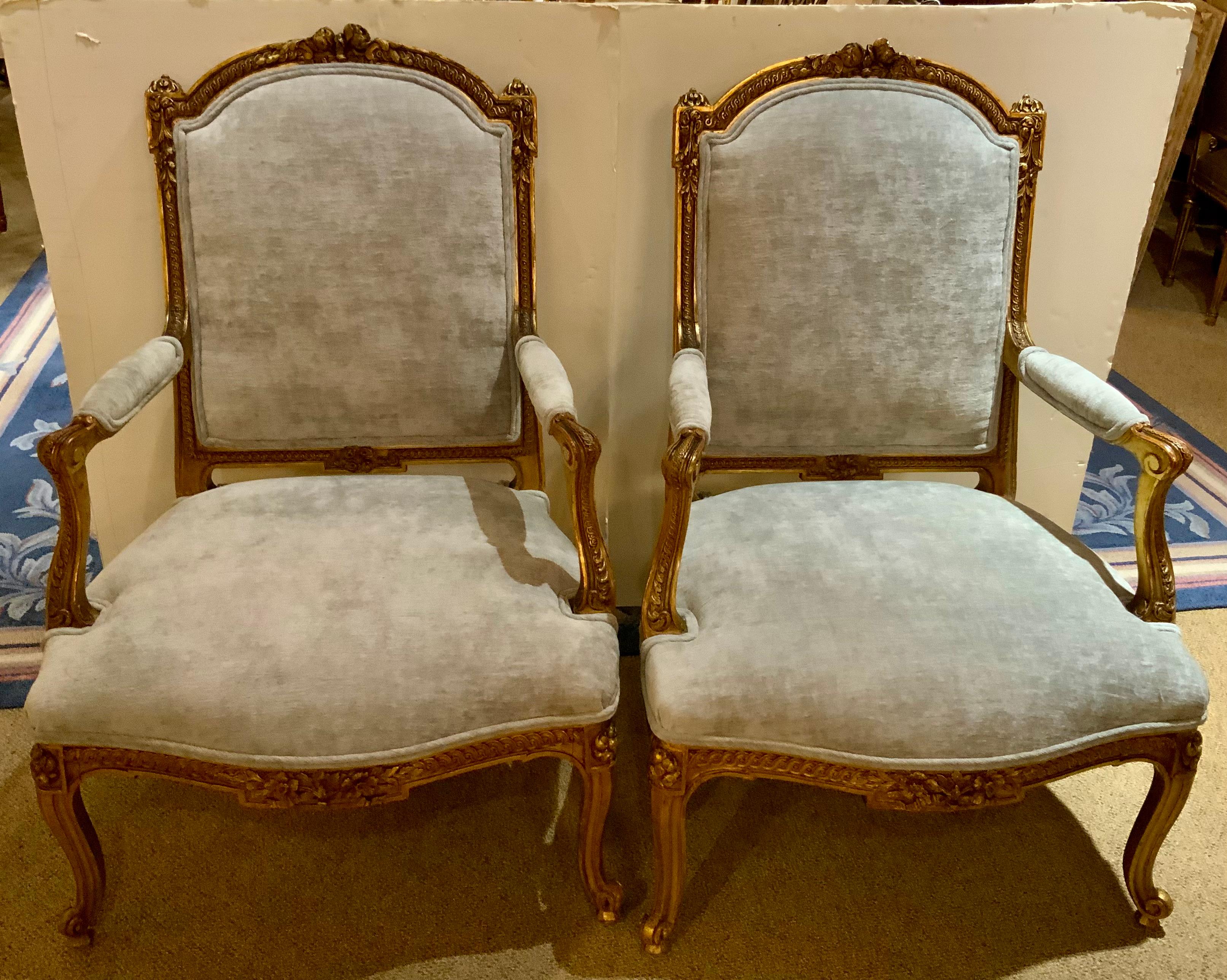 These fine chairs have a domed and padded back surmounted 
By a floral crest, joined by padded arms to the like seat, raised
Above a floral guilloche-carved apron on molded cabriole legs ending in scrolled toes, covered in a new fabric in pale