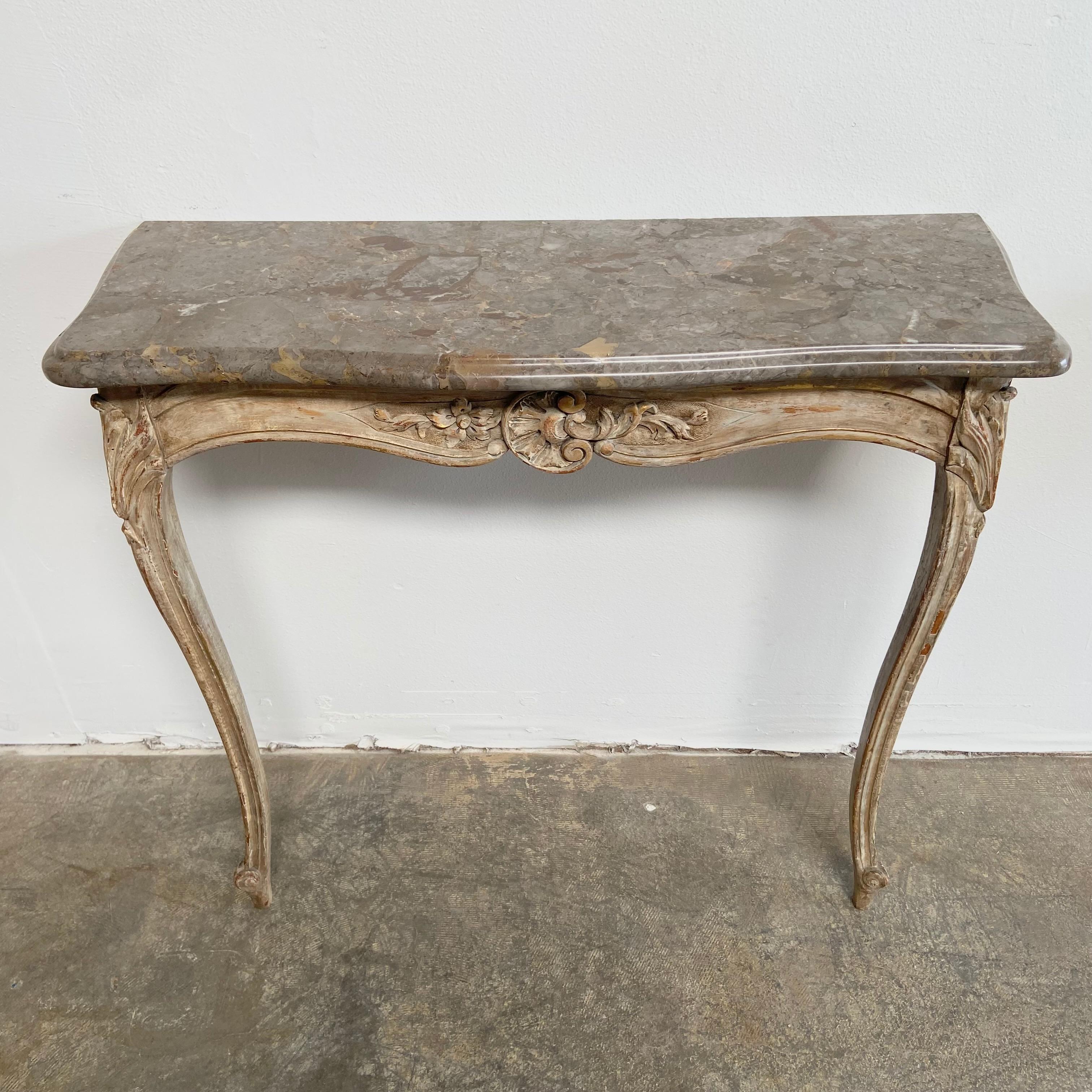 Pair of Louis XV style marble top console tables
Painted in a beautiful faux patina finish, with taupe and gray stone tops.
Sold as a set, these attach to the wall with an anchor bolt, and the marble rests on top the the table.
Each table is