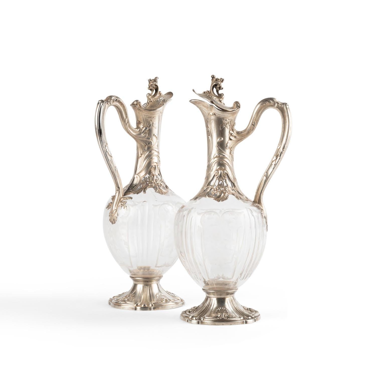 Pair of Louis XV style silver and crystal ewers.

Pair of silver and crystal ewers in the Louis XV style, 19th century.    
h: 22cm , D: 11cm