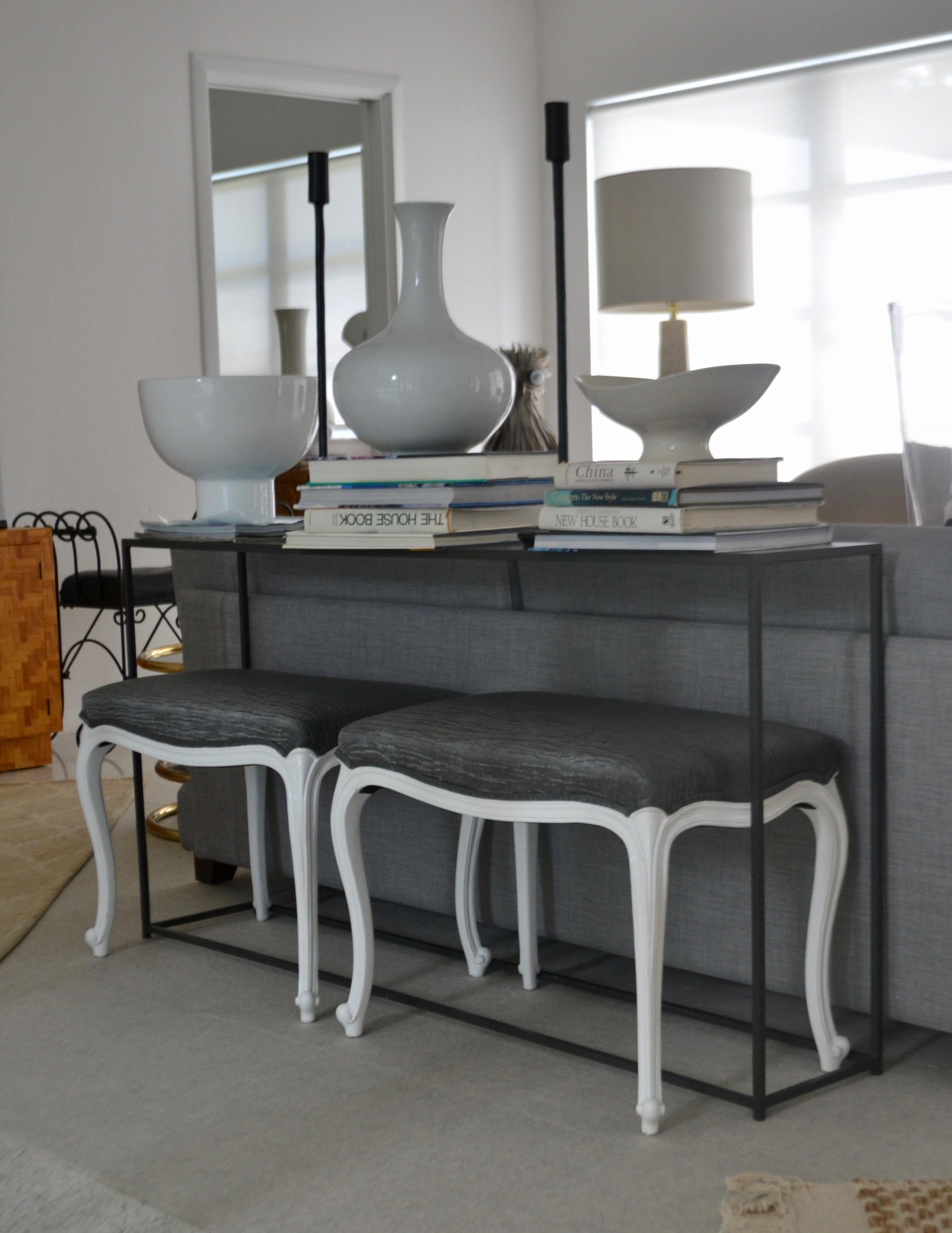 Glamorous pair of Louis XV style white lacquered benches, circa 1950s-1960s. These exquisite art moderne inspired stools are upholstered in a sharkskin grey gloss glazed watered effect fabric.