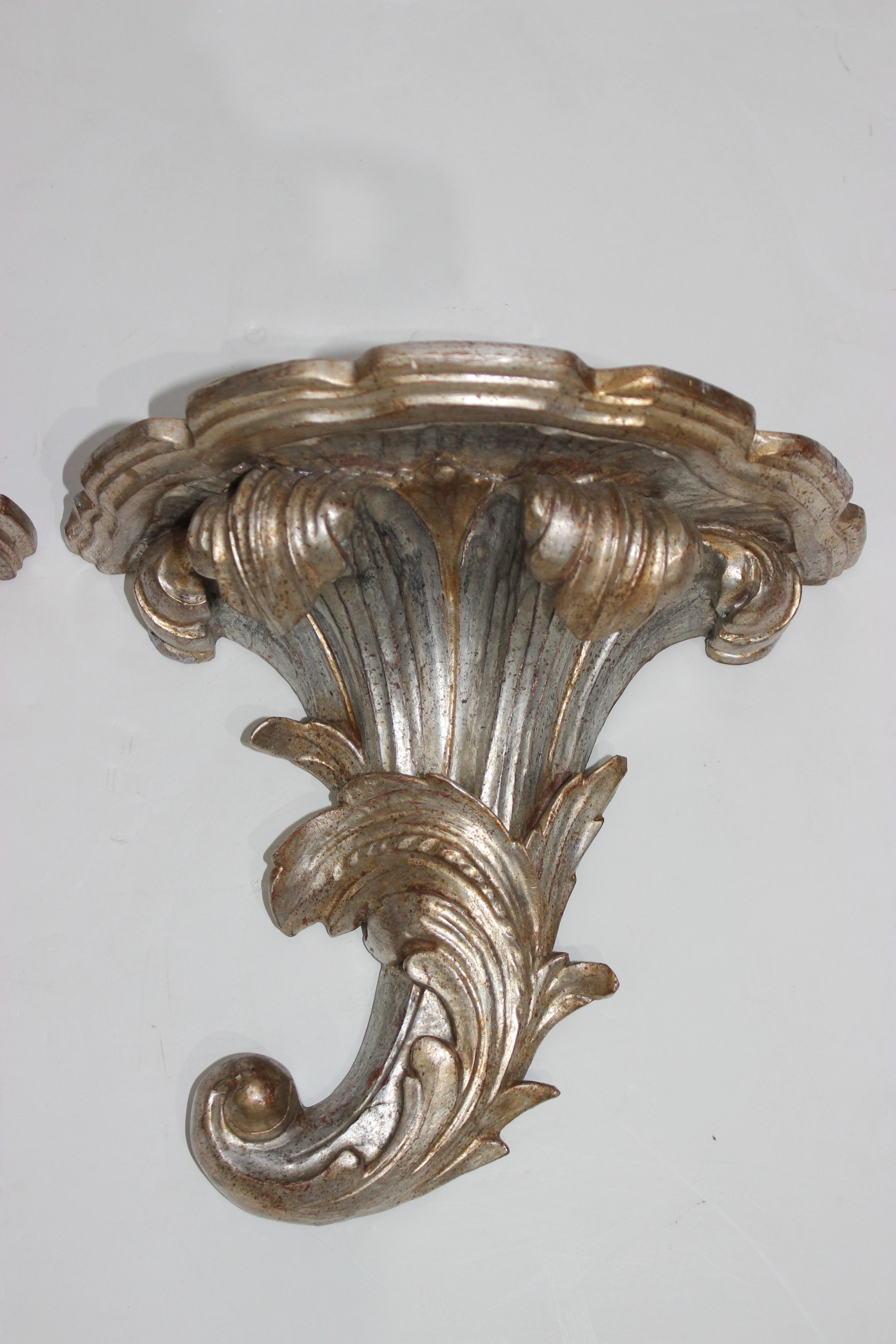 This stylish pair of Italian Louis XV style wall brackets are hand carved wood with a silver leaf finish.