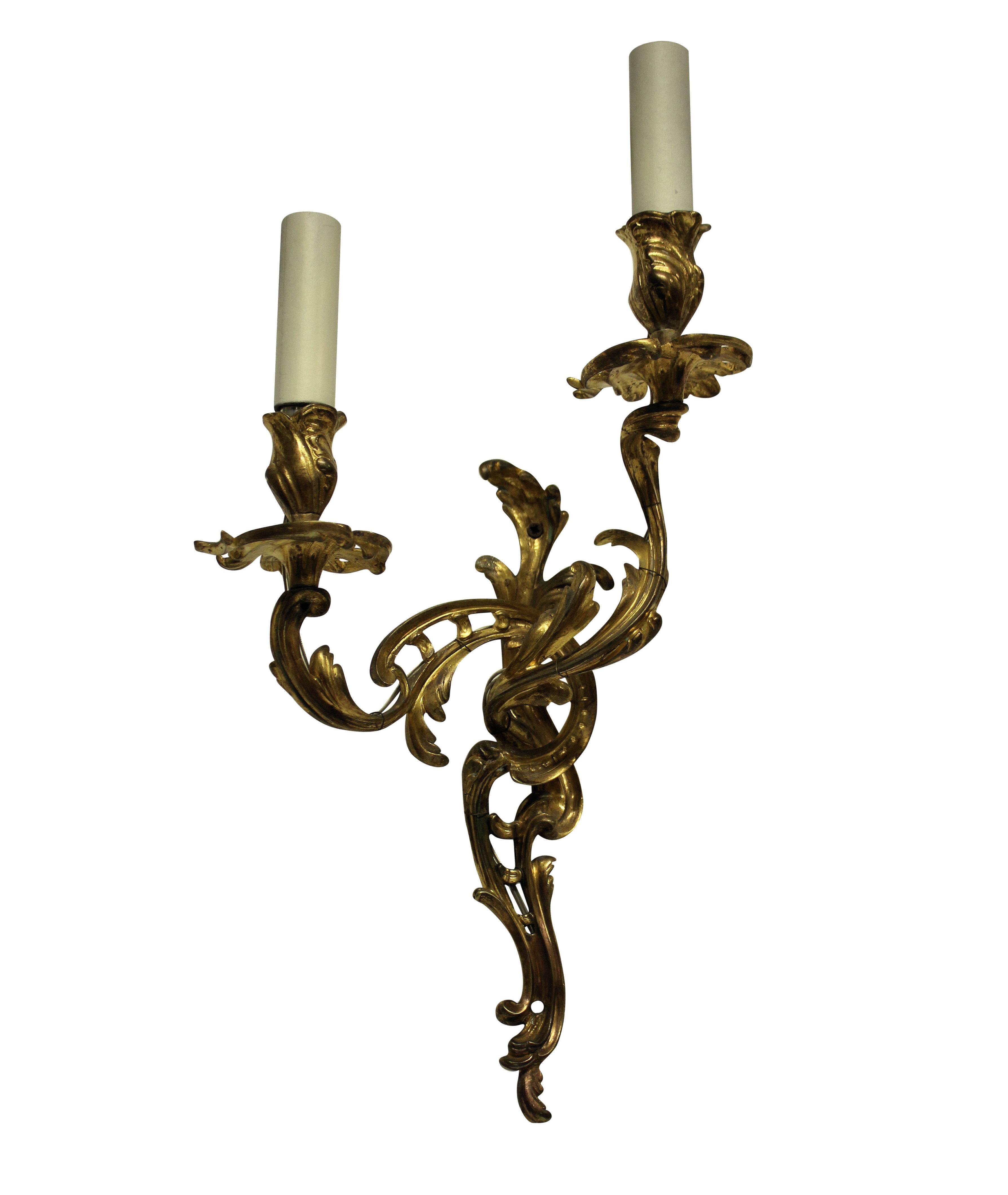 A pair of French gilt bronze Louis XV style twin branch wall sconces.
