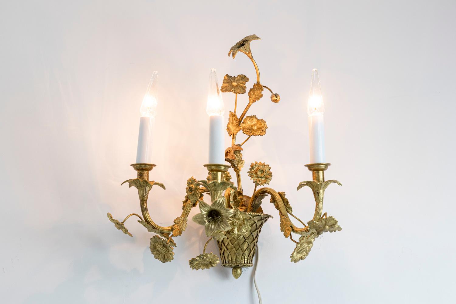 Pair of Louis XV style wall sconces in gilt bronze with three fires. Braided base in pot shaped on which are fixed three S-shaped branches with floral pattern. Cups decorated with flowers.

Work realized in the 1900s.

New and functional
