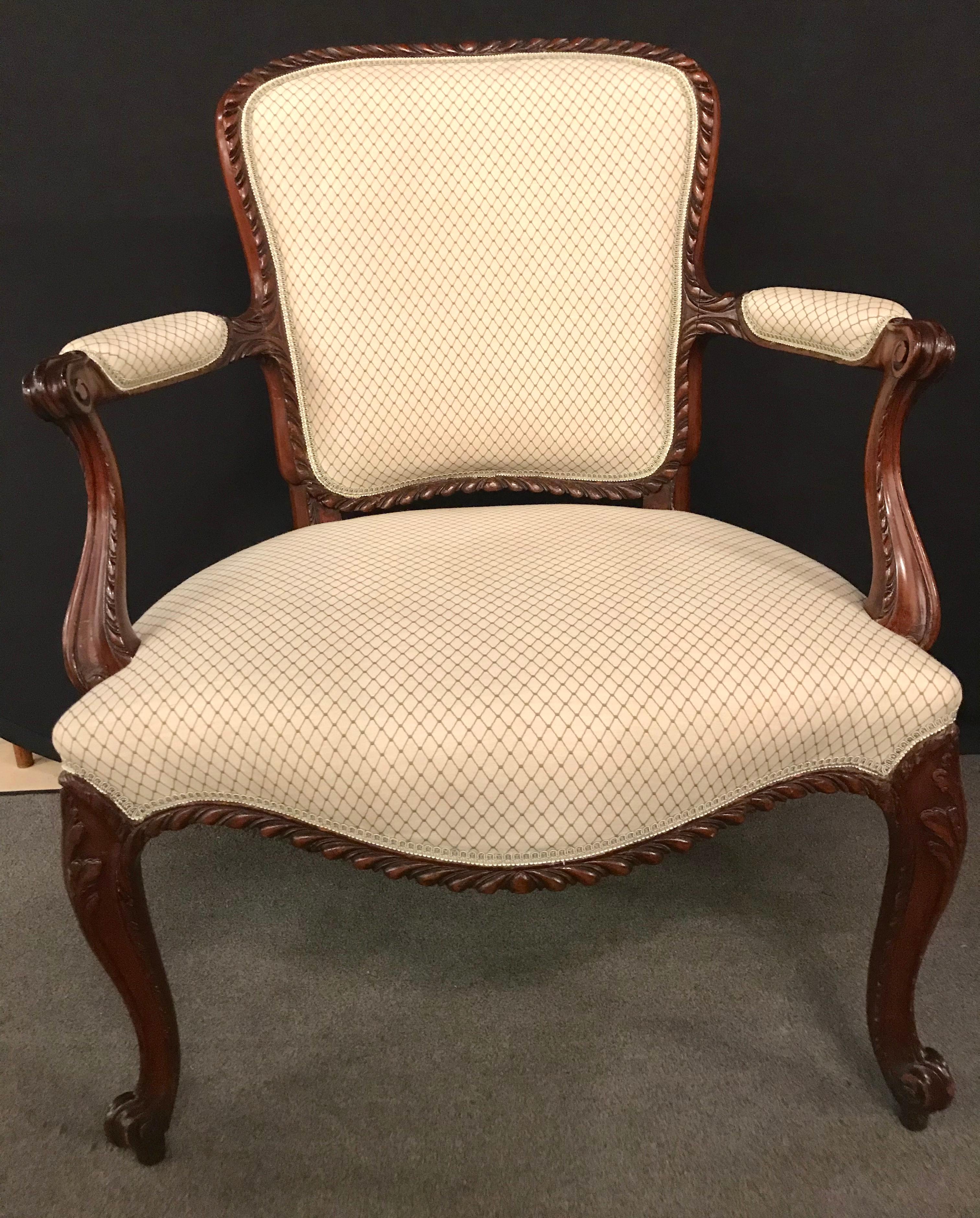 A fine pair of Louis XV style walnut fauteuils or Bergères in a Scalamandre Fabric. A simply understated pair of carved arm chairs in the finest fabric having a stripped fabric in the back with a tweed design seat and backrest.