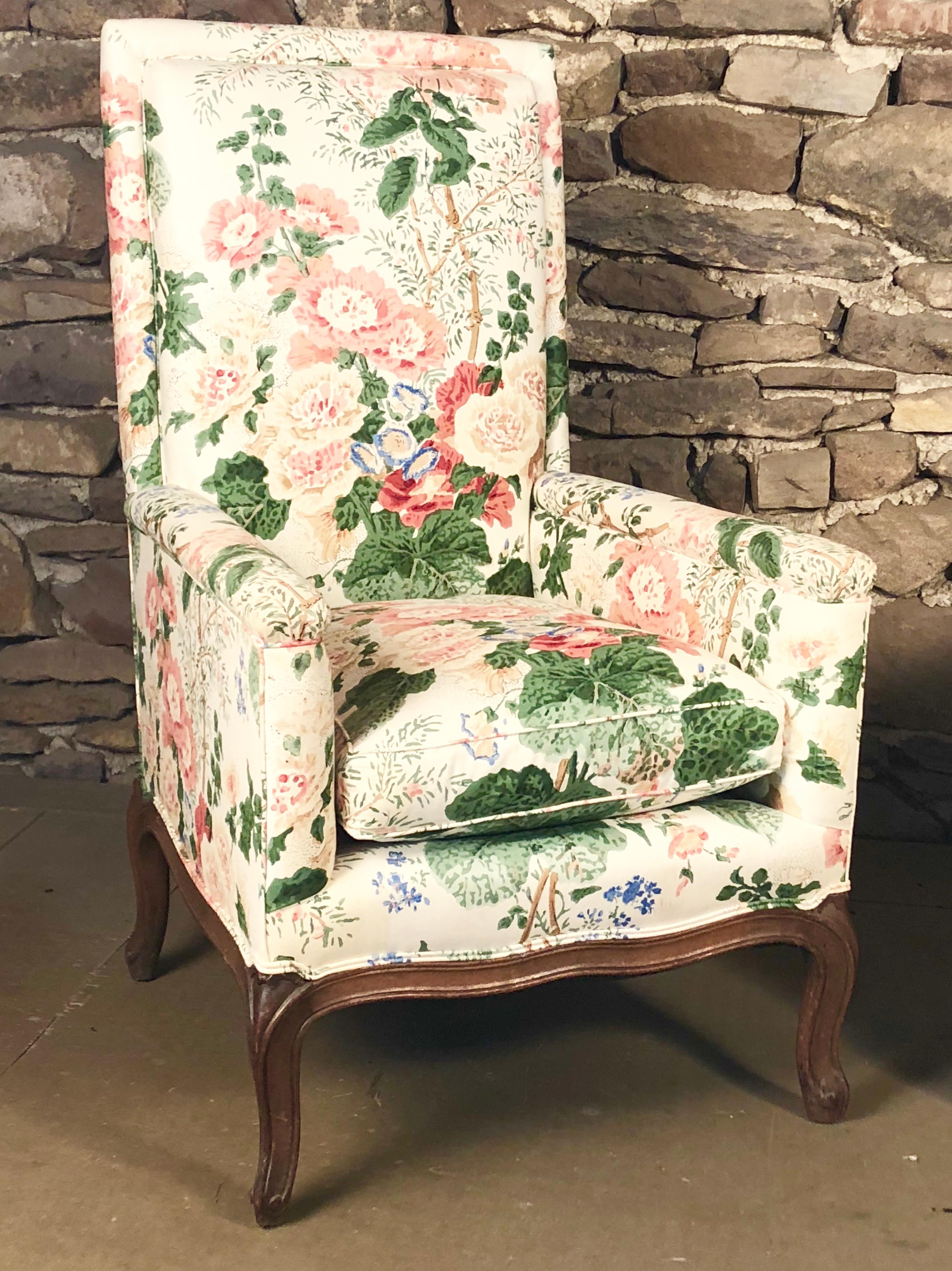 A pair of French Louis XV upholstered armchairs with high backs and loose cushion seat, the cherrywood frame exposed at the base with cabriole legs and a scalloped apron, circa 1790.