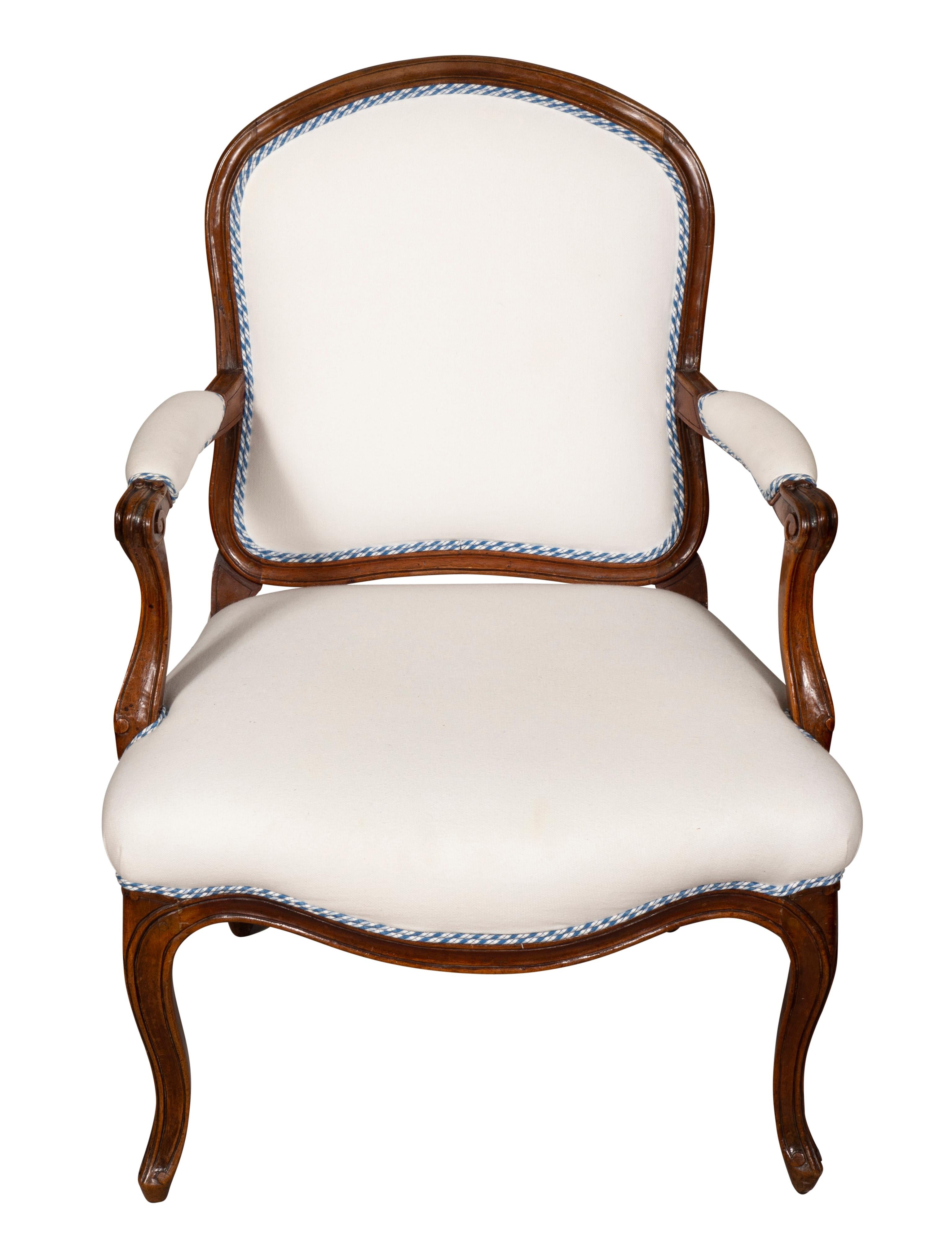With arched back and serpentine seat, carved arms raised on cabriole legs. Nice upholstery.