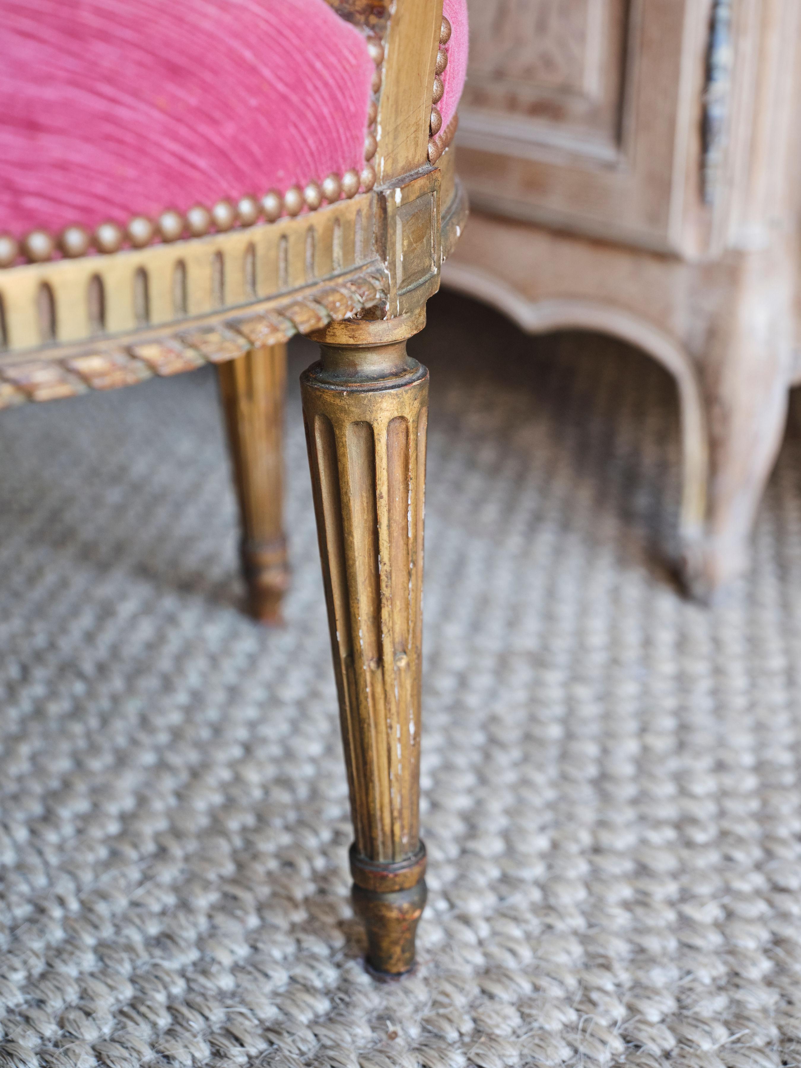 These stunning 18th century pink armchairs really stand out and make a statement! Originating from the Louis XVI period, the chairs have ornate wood carved details all over. The legs of the chair have lined wood details with floral carved detail